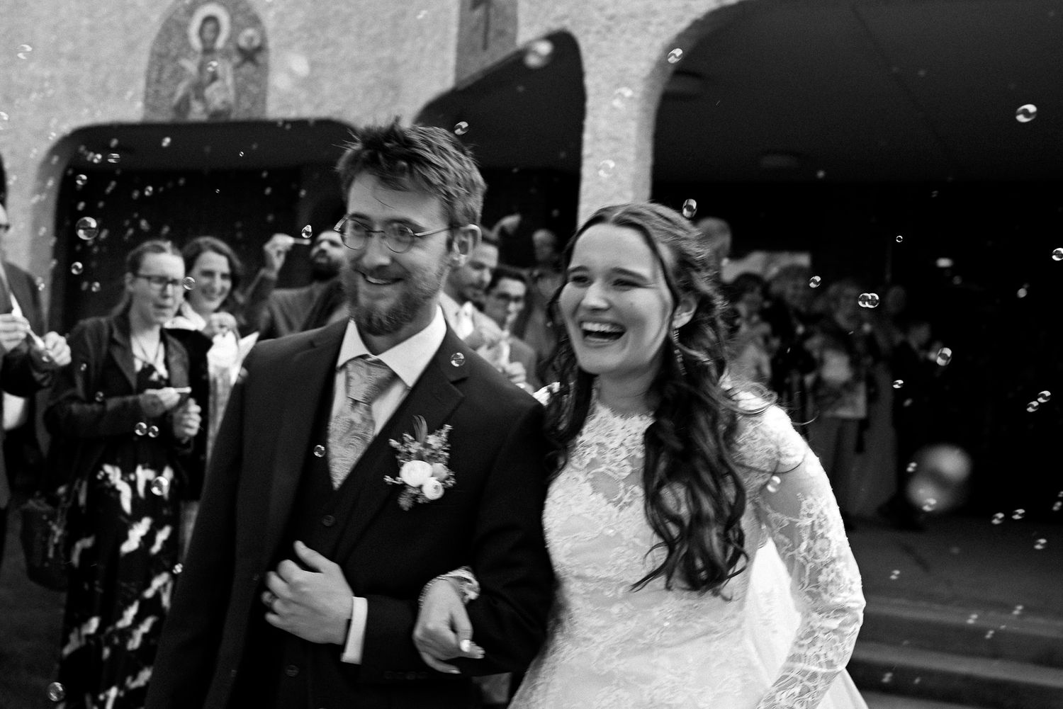 Wedding celebration with guests dancing and celebrating in formal attire.