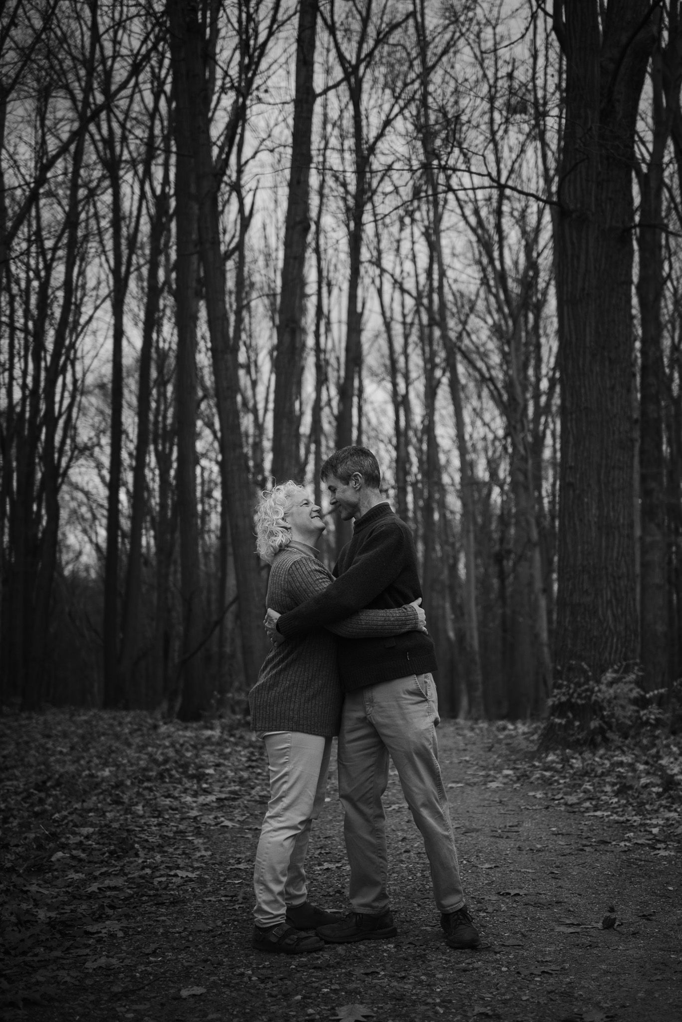 A playful black and white photo sequence showing two figures dancing in a forest.