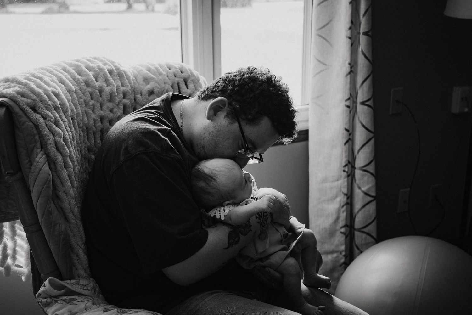Black and white photo of someone resting peacefully by window light.