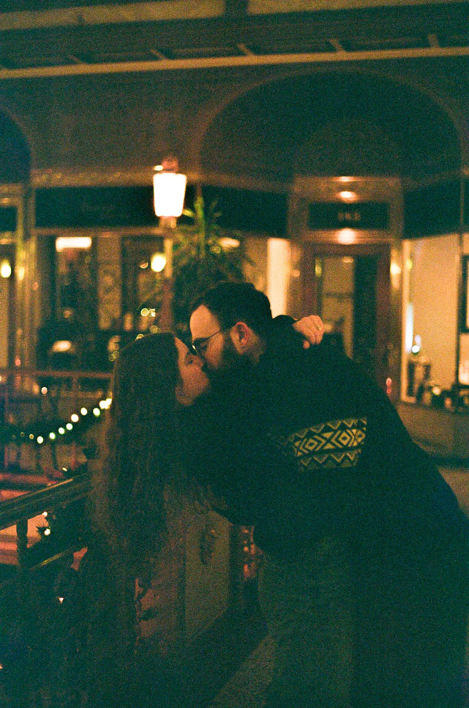 People gather in a dimly lit bar with warm ambient lighting creating a cozy evening atmosphere.