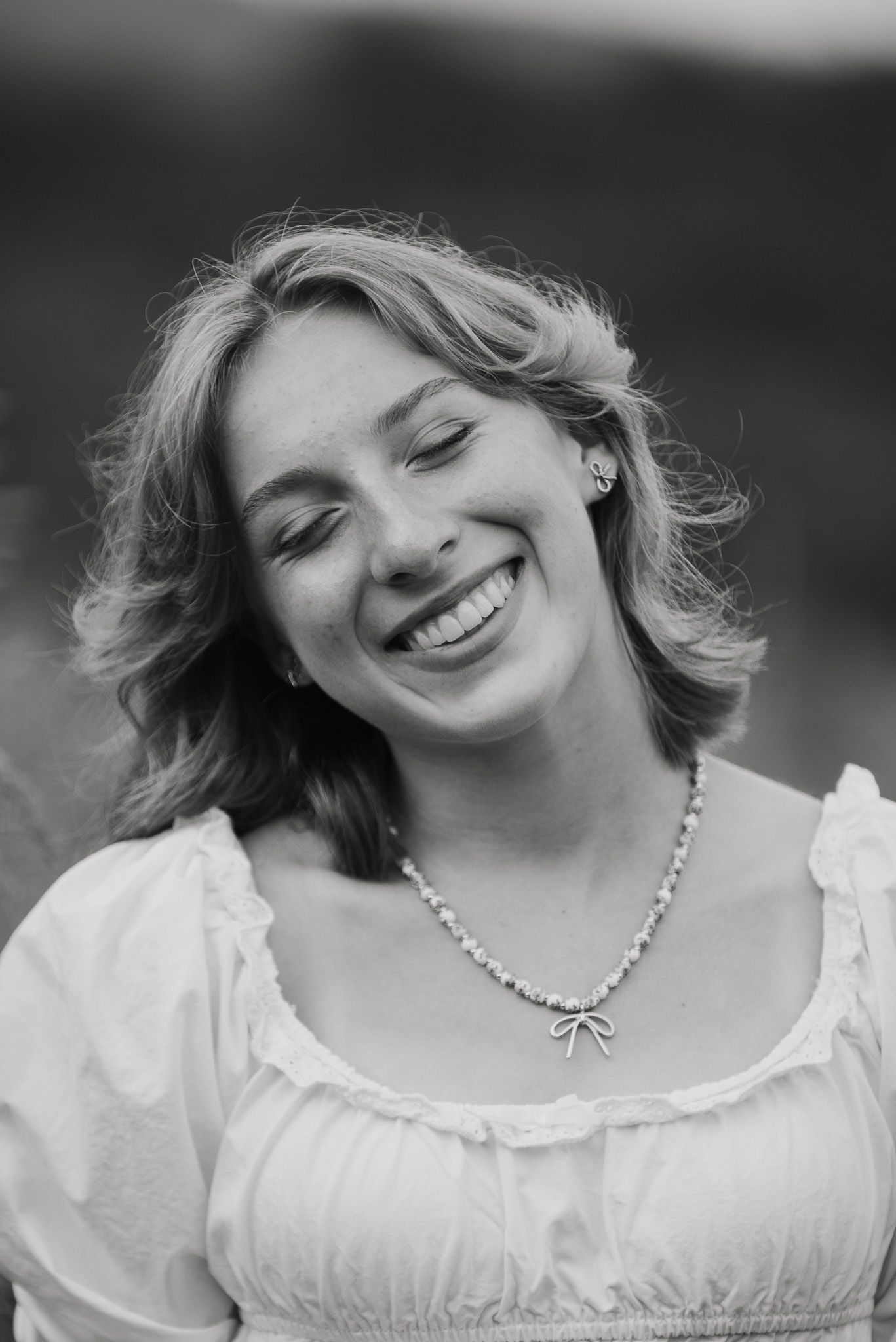 A black and white portrait showcasing joy and vintage-inspired fashion.