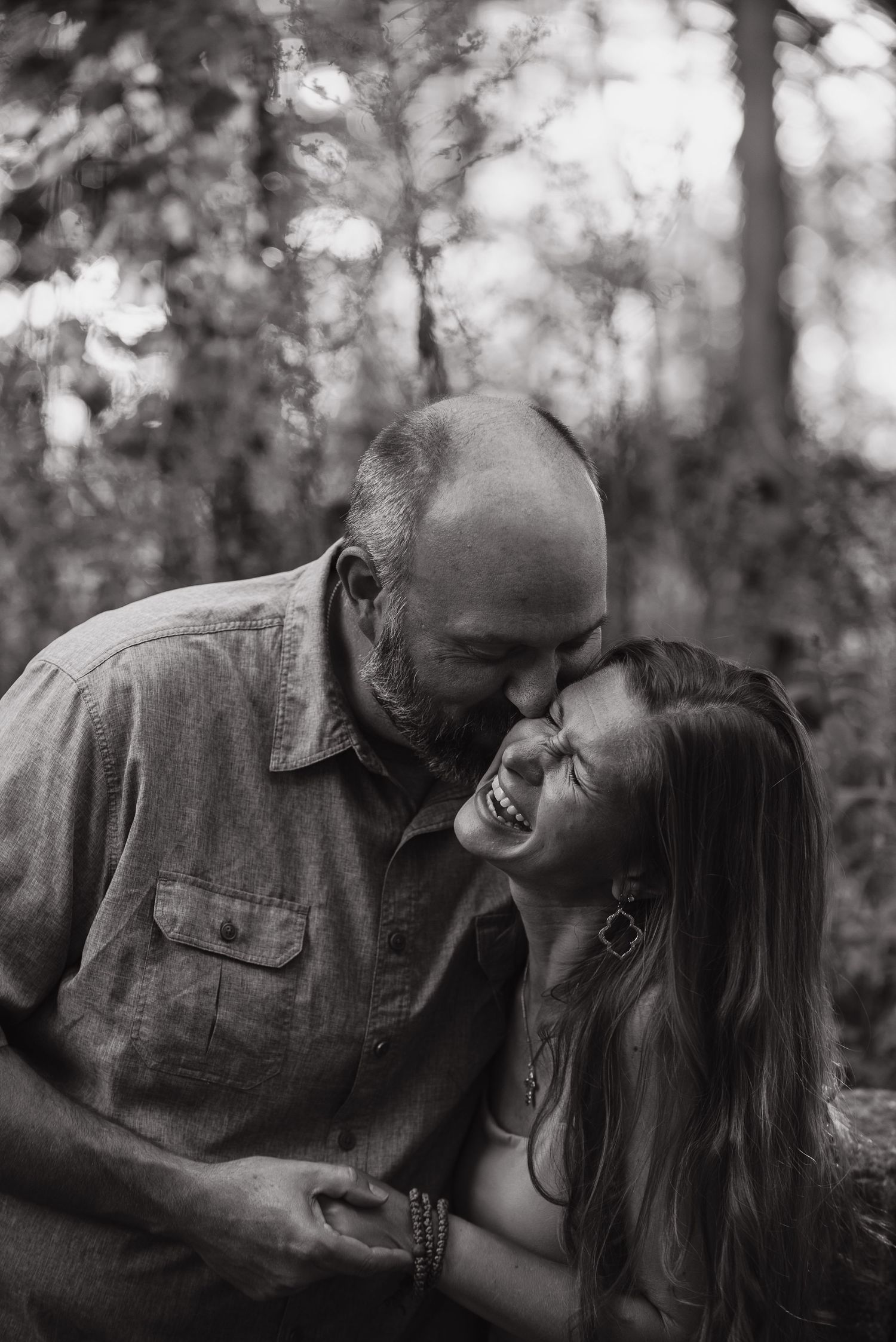 A romantic black and white photo sequence showing a couple embracing and sharing intimate moments in a forest setting.