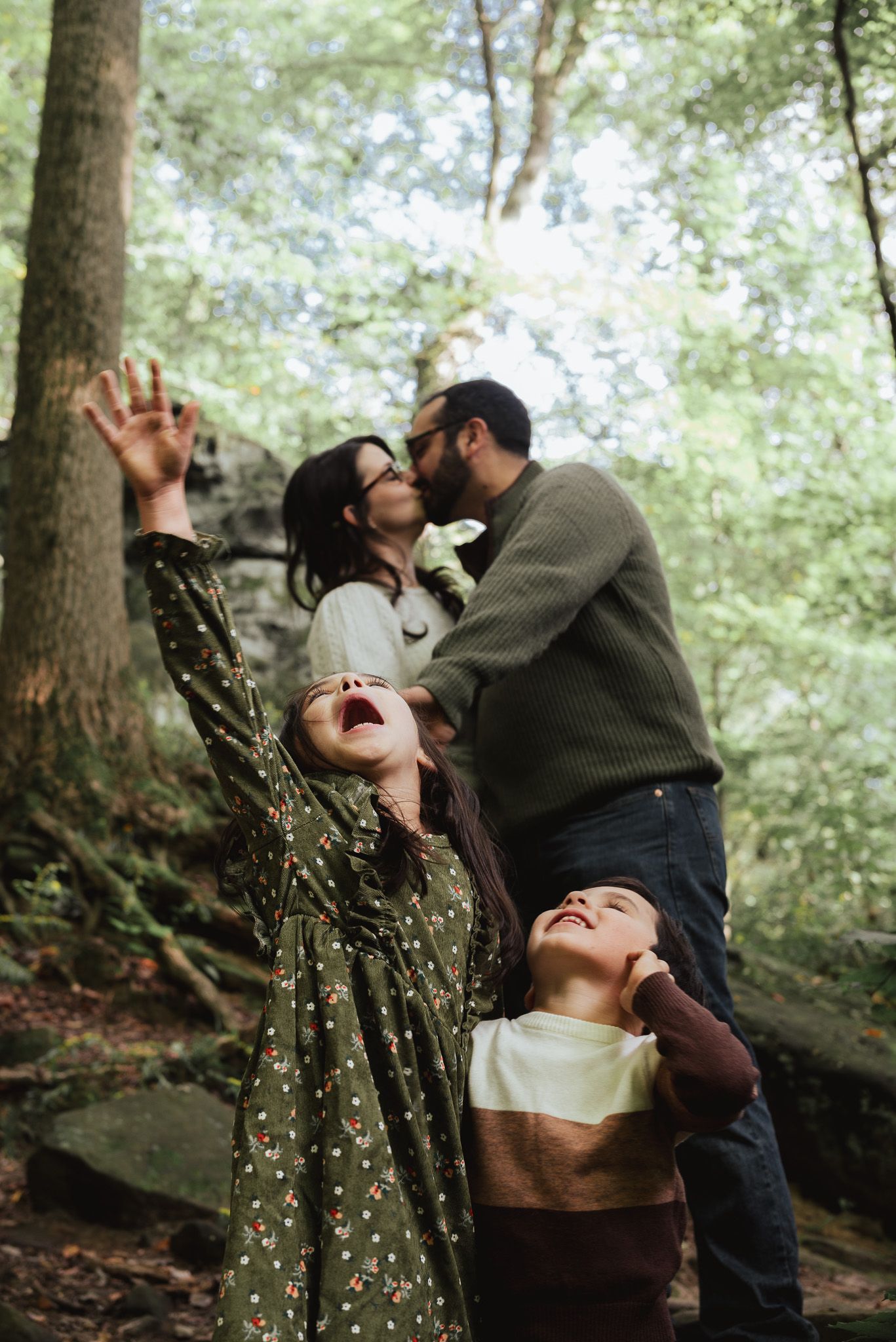 Playful and joyful moments captured between a family in a lush forest setting.