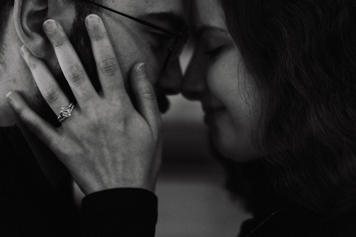 A tender intimate moment captured in black and white as two people share a close embrace.