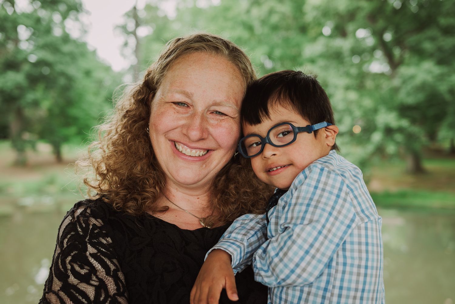 A warm embrace shared between parent and child in a lush green park setting.