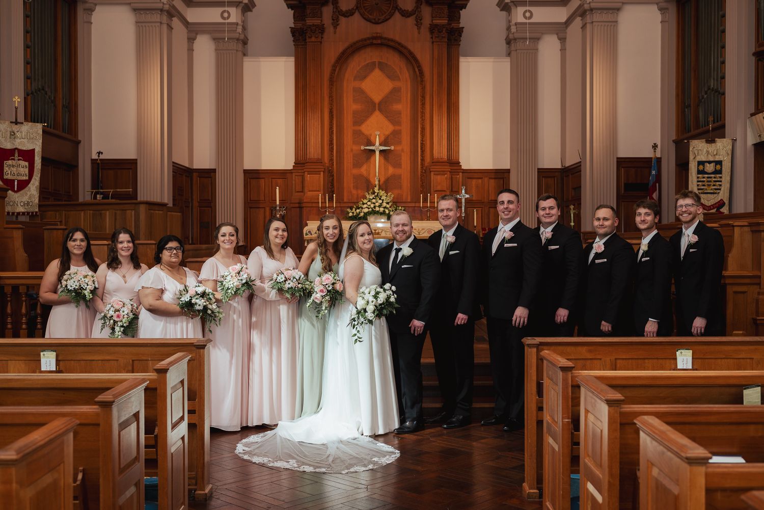 Traditional church wedding ceremony with bridal party in sage green and black attire.
