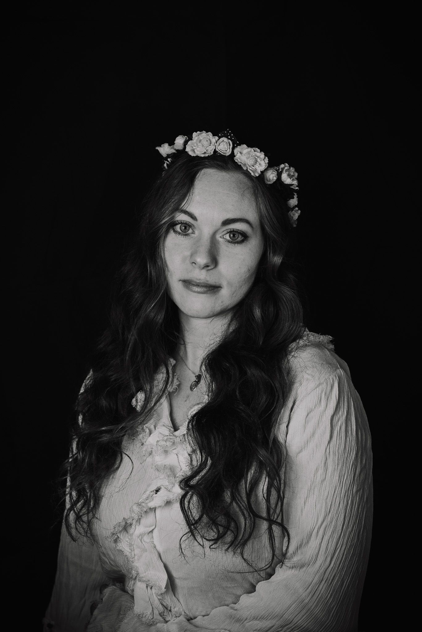 Artistic black and white portraits with floral crown and vintage-inspired styling.