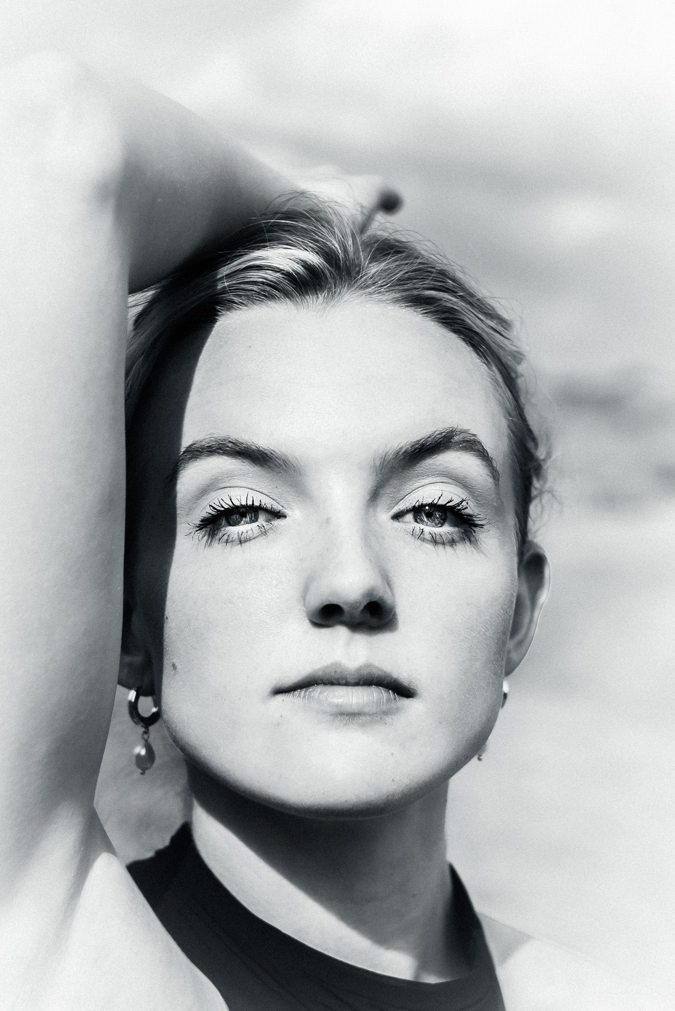 High contrast black and white close-up portrait with dramatic angles.