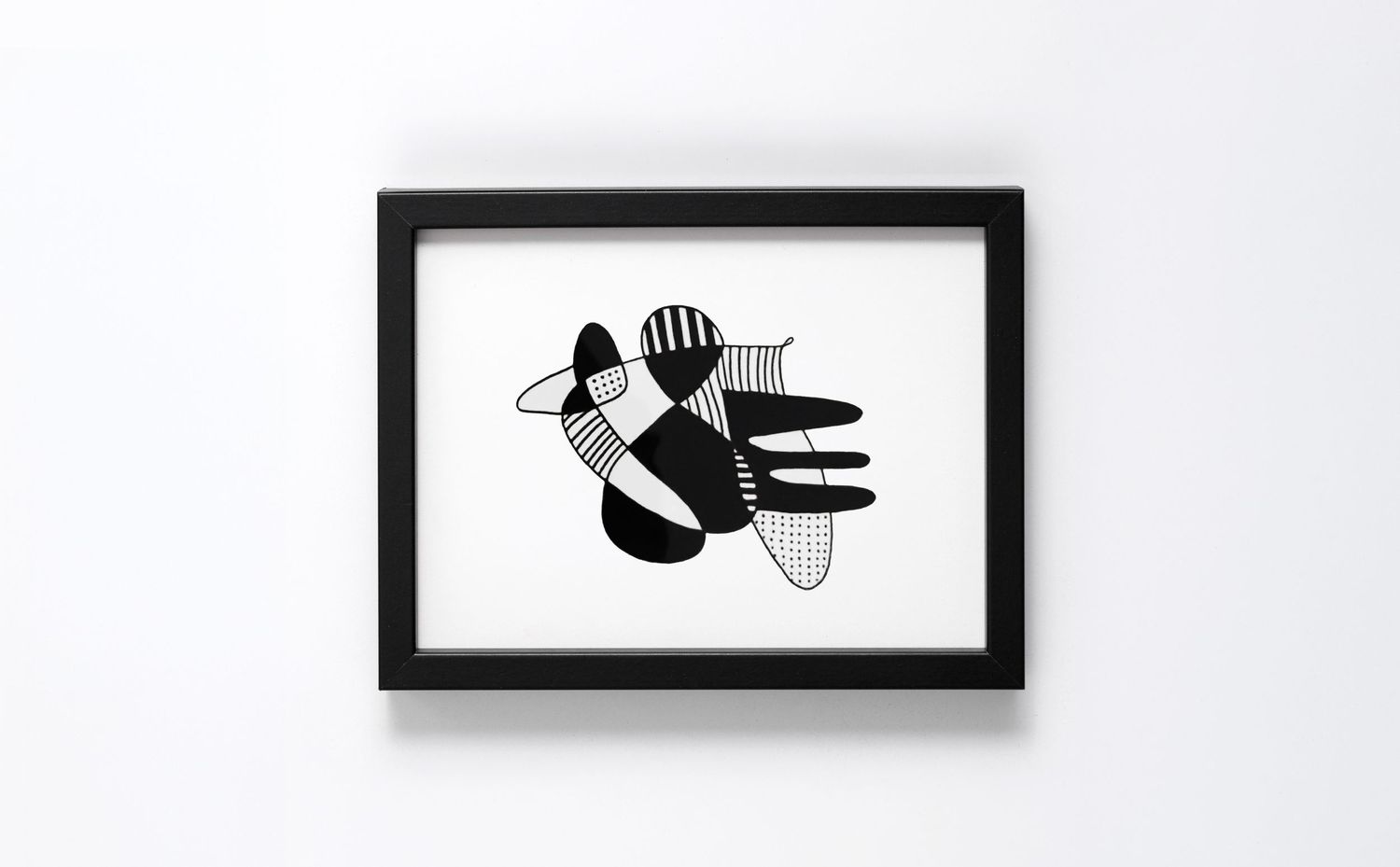 Black framed abstract art print featuring bold black and white geometric shapes on white background.
