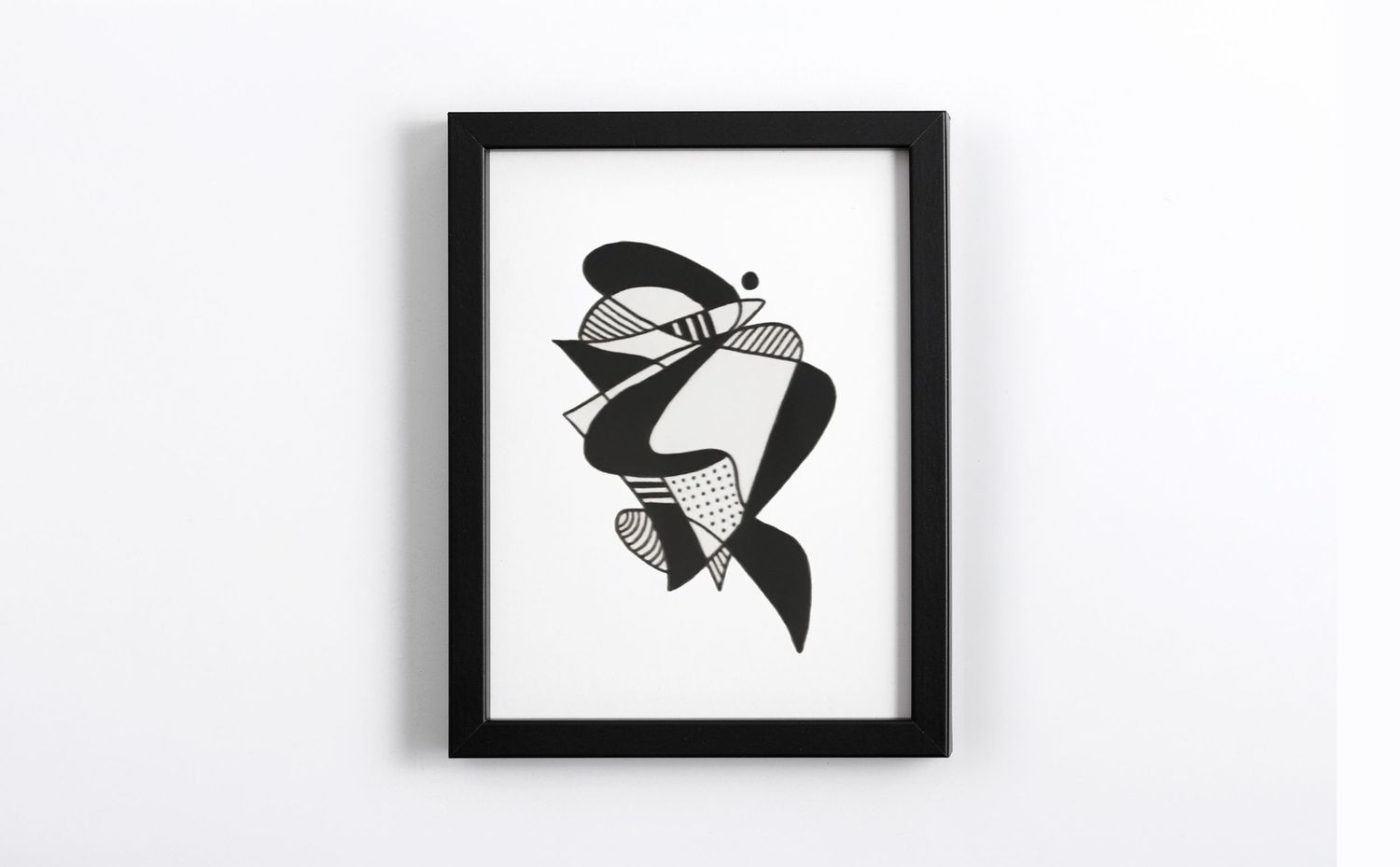 Black and white abstract art print in a black frame featuring bold geometric shapes and flowing curves.