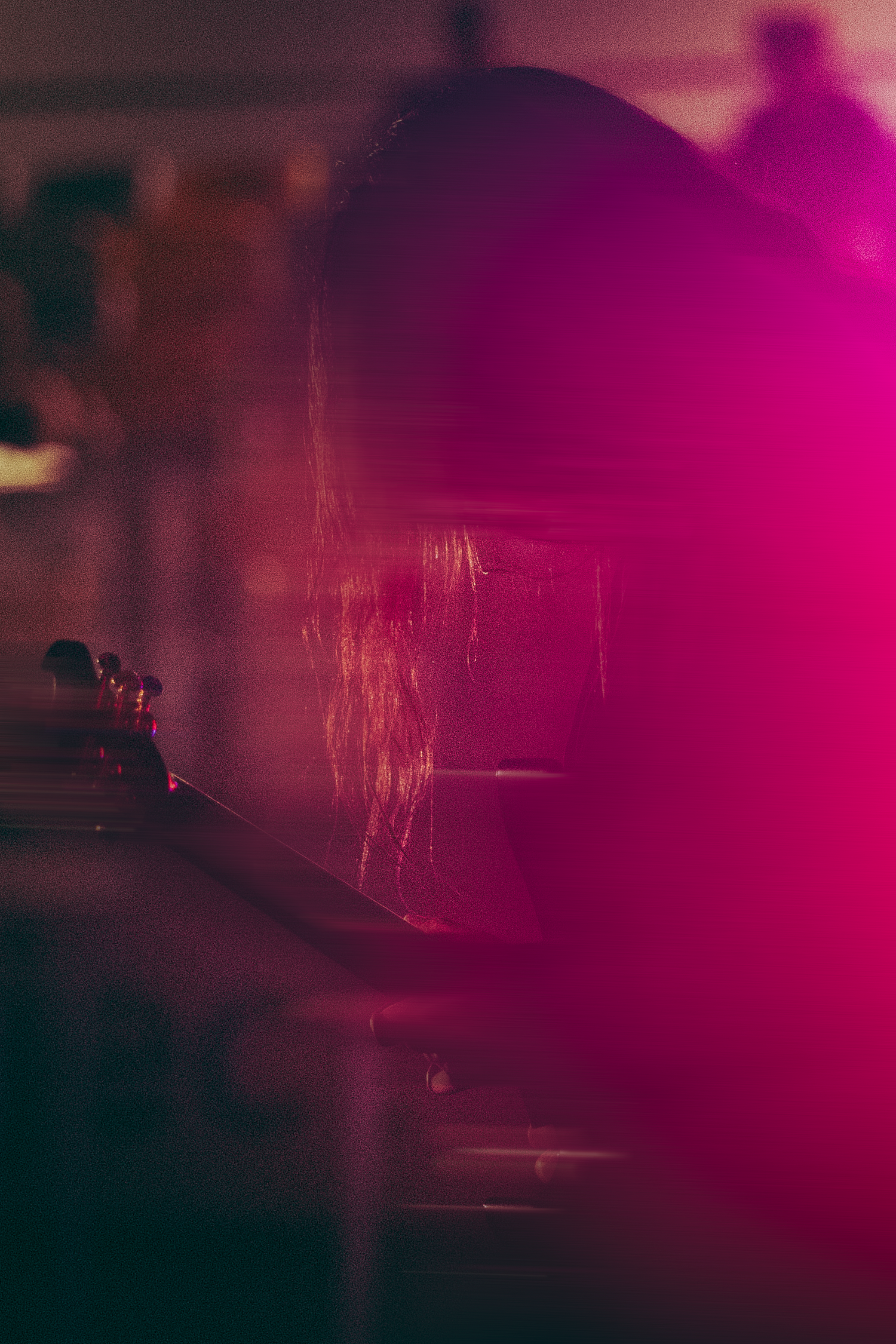 Atmospheric pink-lit silhouette of musician on stage with dramatic magenta stage lighting effect.