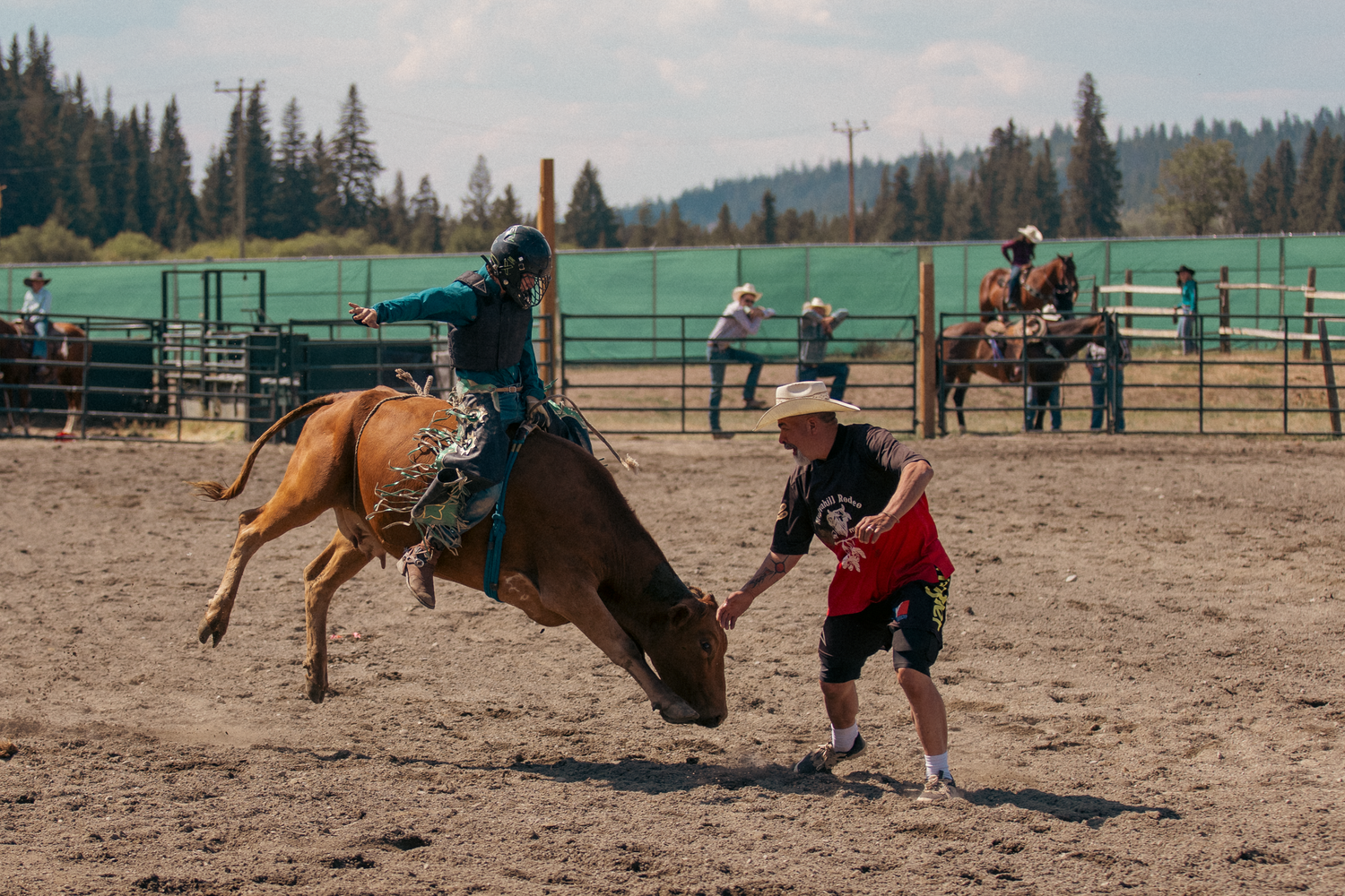 A rodeo clown assists a bucking bronco rider during a thrilling bareback riding competition outdoors.