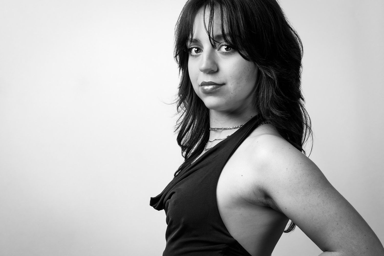 Portrait en noir et blanc d'une jeune femme, mettant en valeur le regard, la lumière et les contrastes.