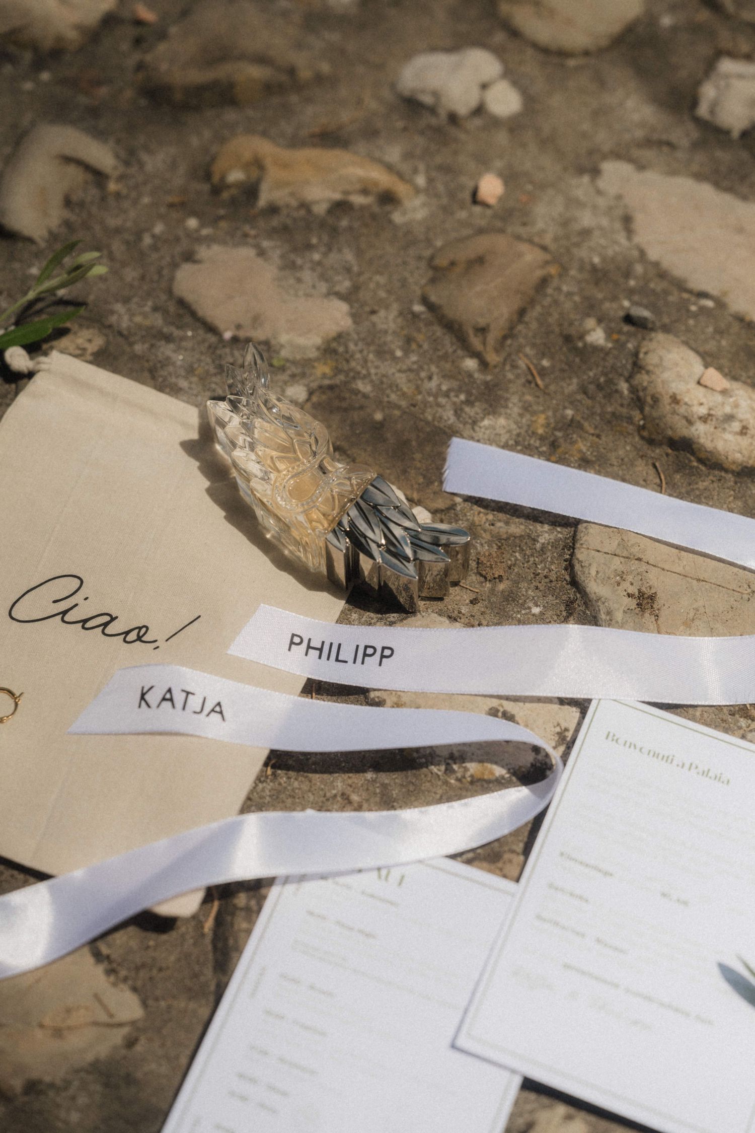 Wedding place cards for Katja and Philipp with white ribbons on rustic ground with sage bundle.