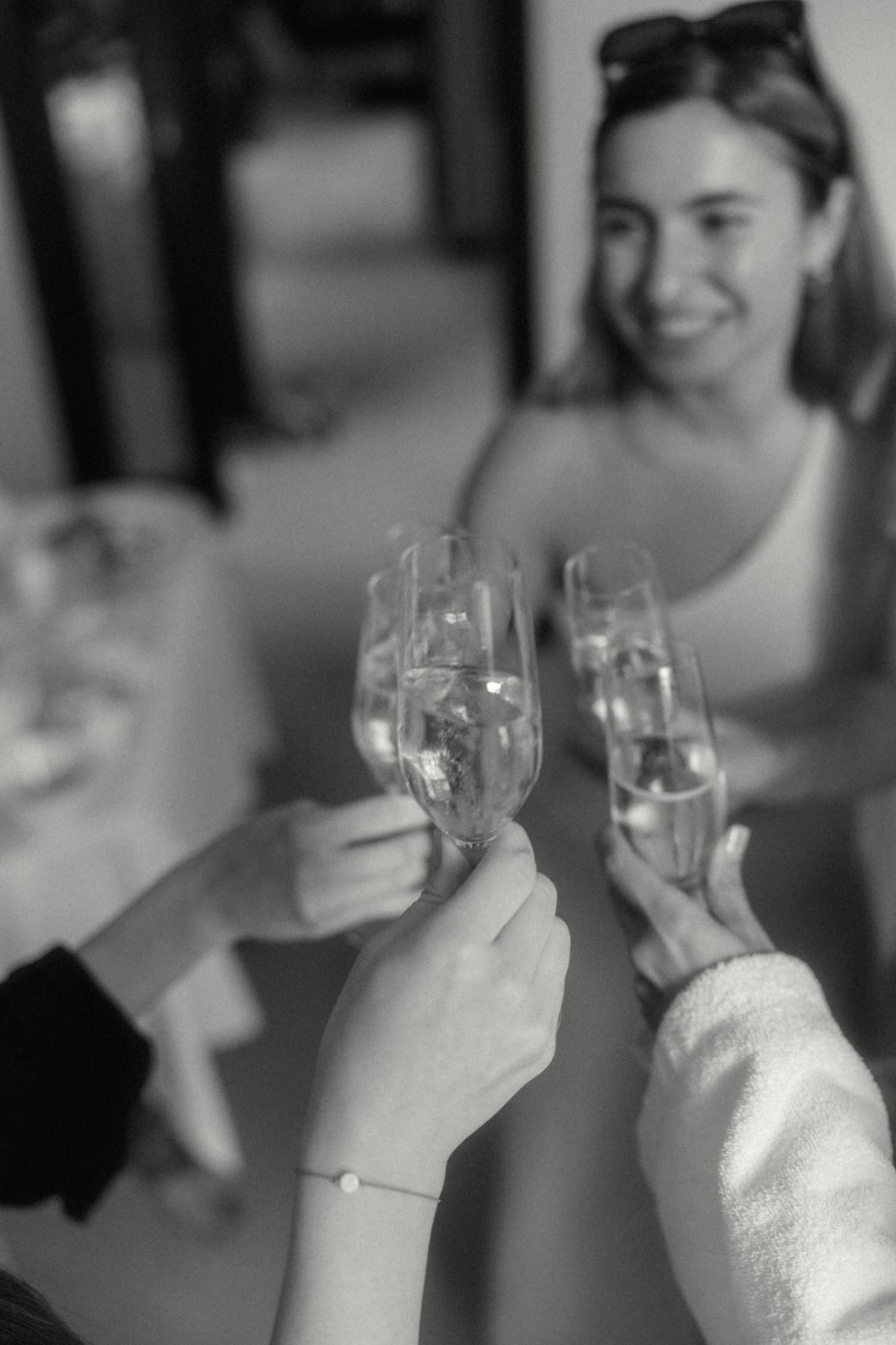 Black and white photo of women toasting with champagne glasses at a celebration.
