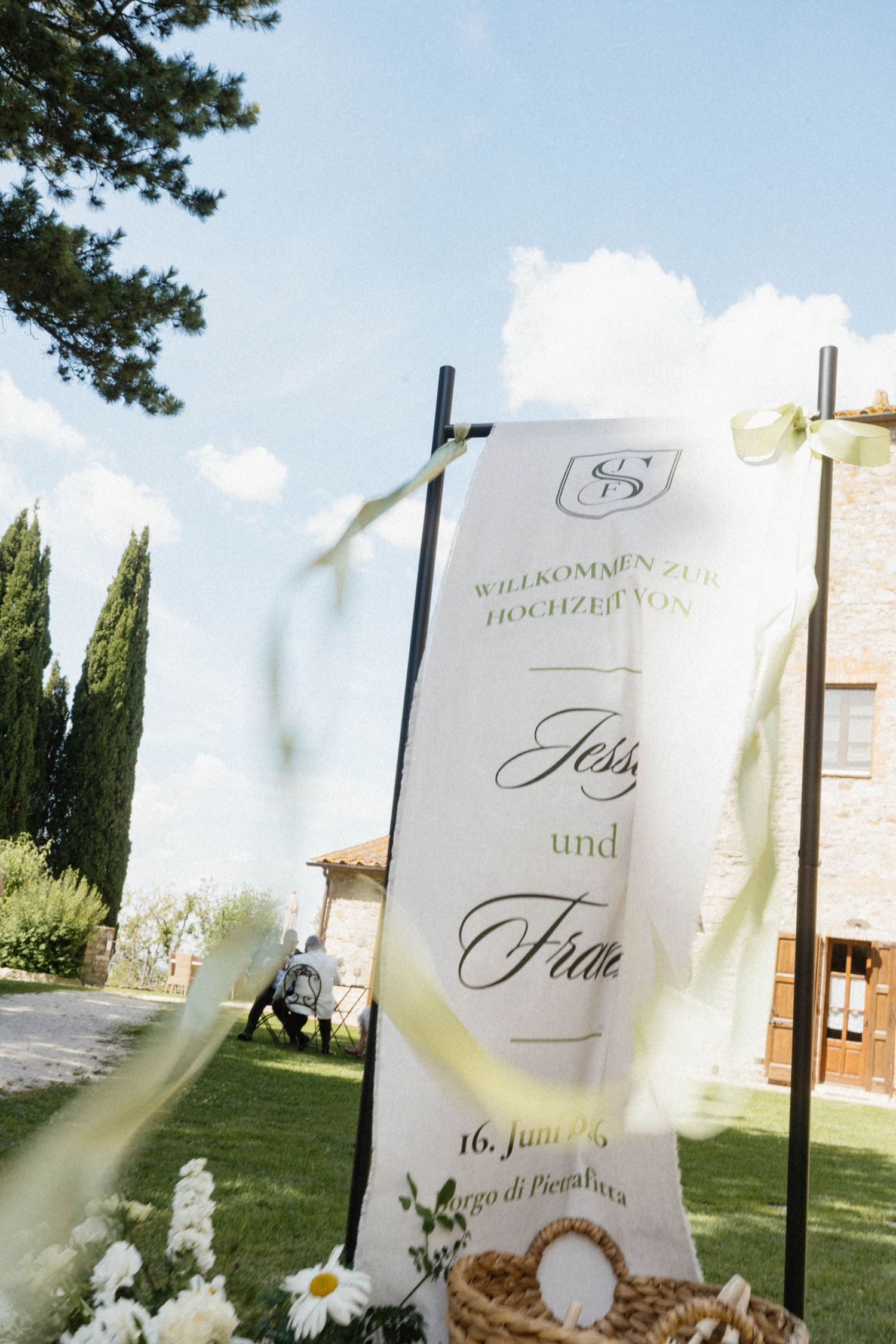 Elegant wedding welcome sign reading Willkommen zur Hochzeit with floral decorations at venue entrance.