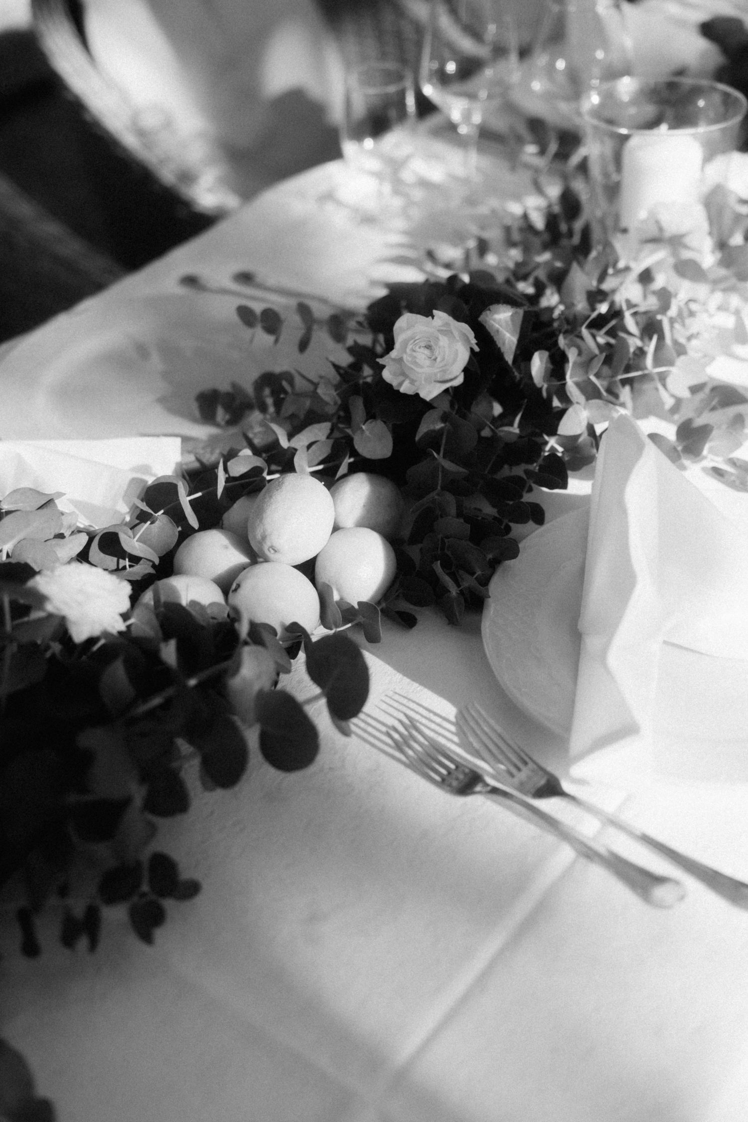Black and white wedding table with roses, eucalyptus, and eggs as elegant centerpiece decoration.