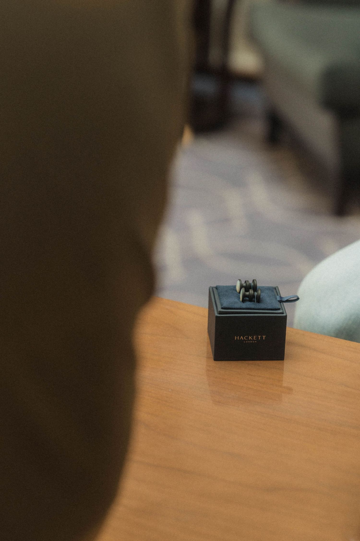 Hackett London cufflink box displayed on a wooden table in an elegant setting.