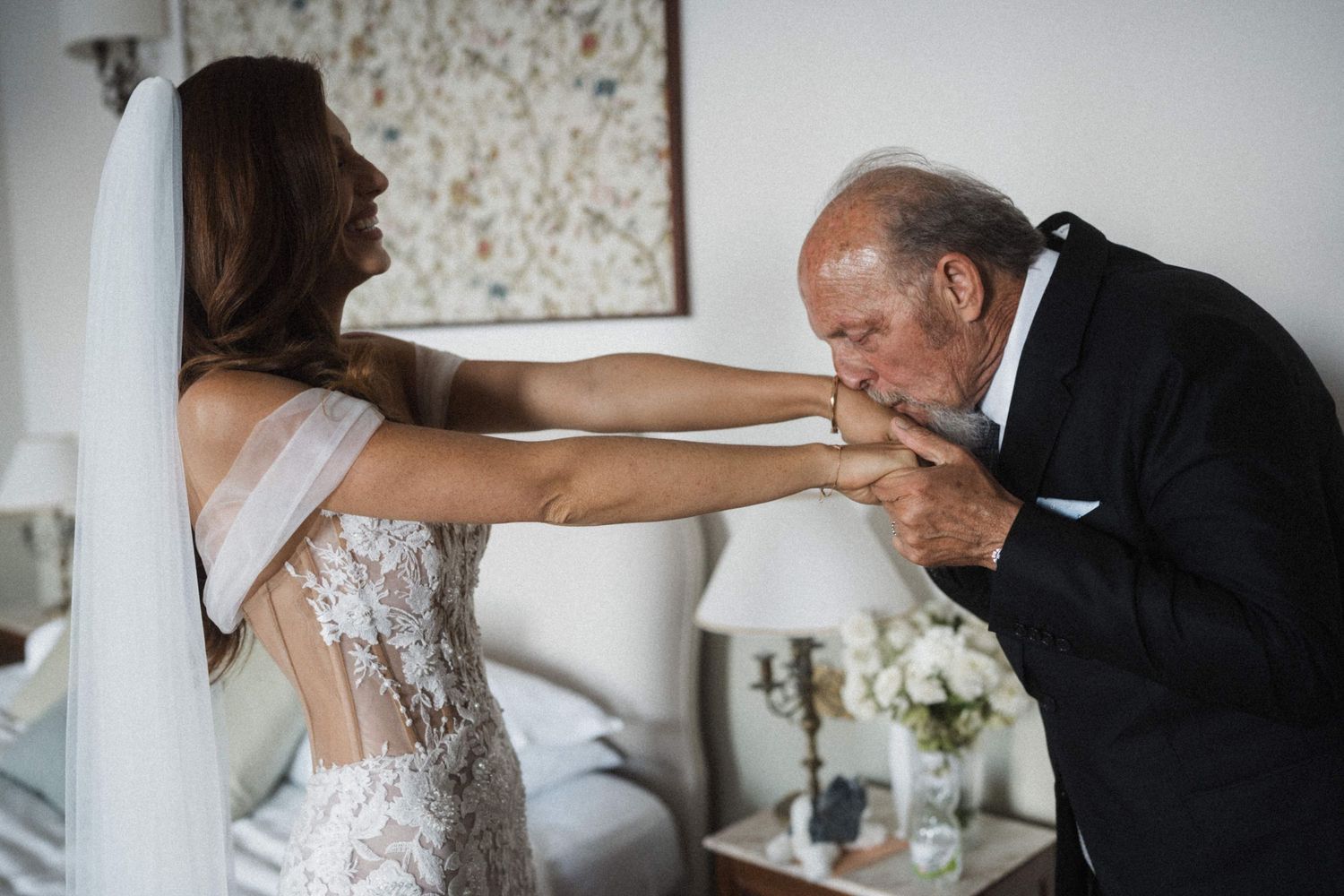 Brautpapa küsst Braut beim First Look der Hochzeit auf Sizilien auf die Hand.