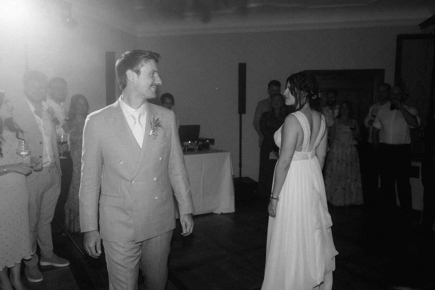 Black and white photo of bride and groom sharing first dance at wedding reception.