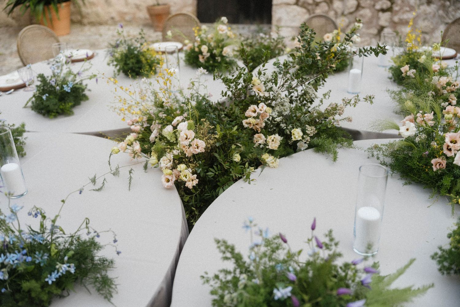 Elegant wedding reception tables adorned with lush greenery and white floral centerpieces.