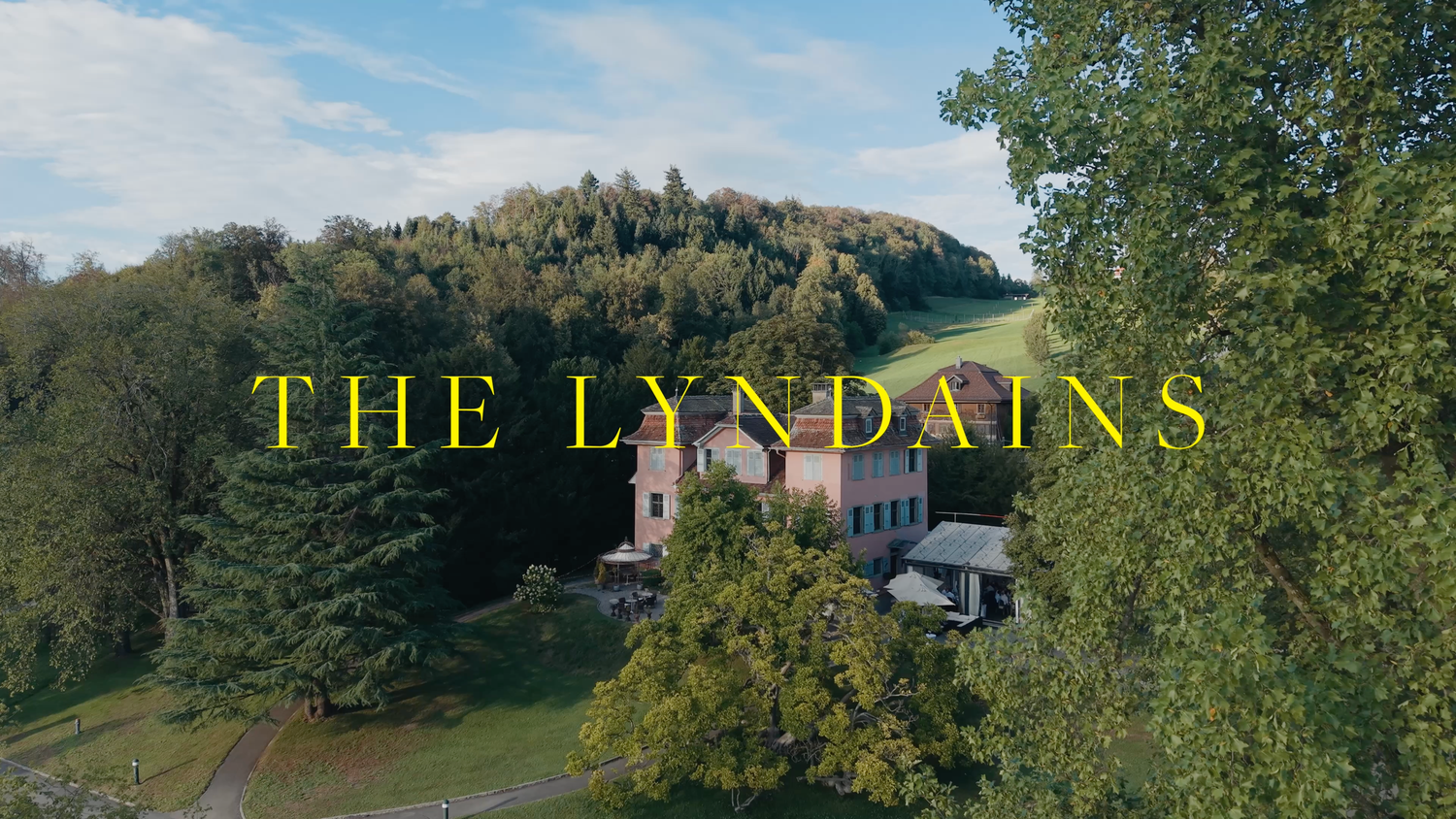 Aerial drone view of The Lyndains, a historic country estate surrounded by lush green trees and rolling hills.