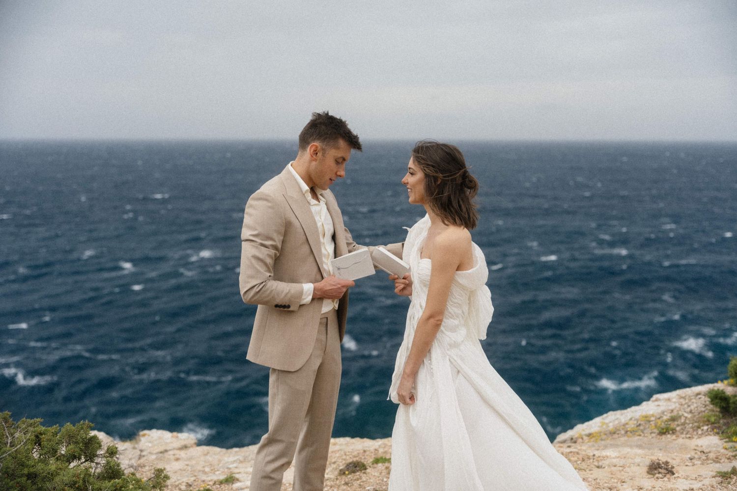 Paar gibt sich auf einer Klippe mit Blick auf das Meer das Eheversprechen bei einem Elopement auf Mallorca.