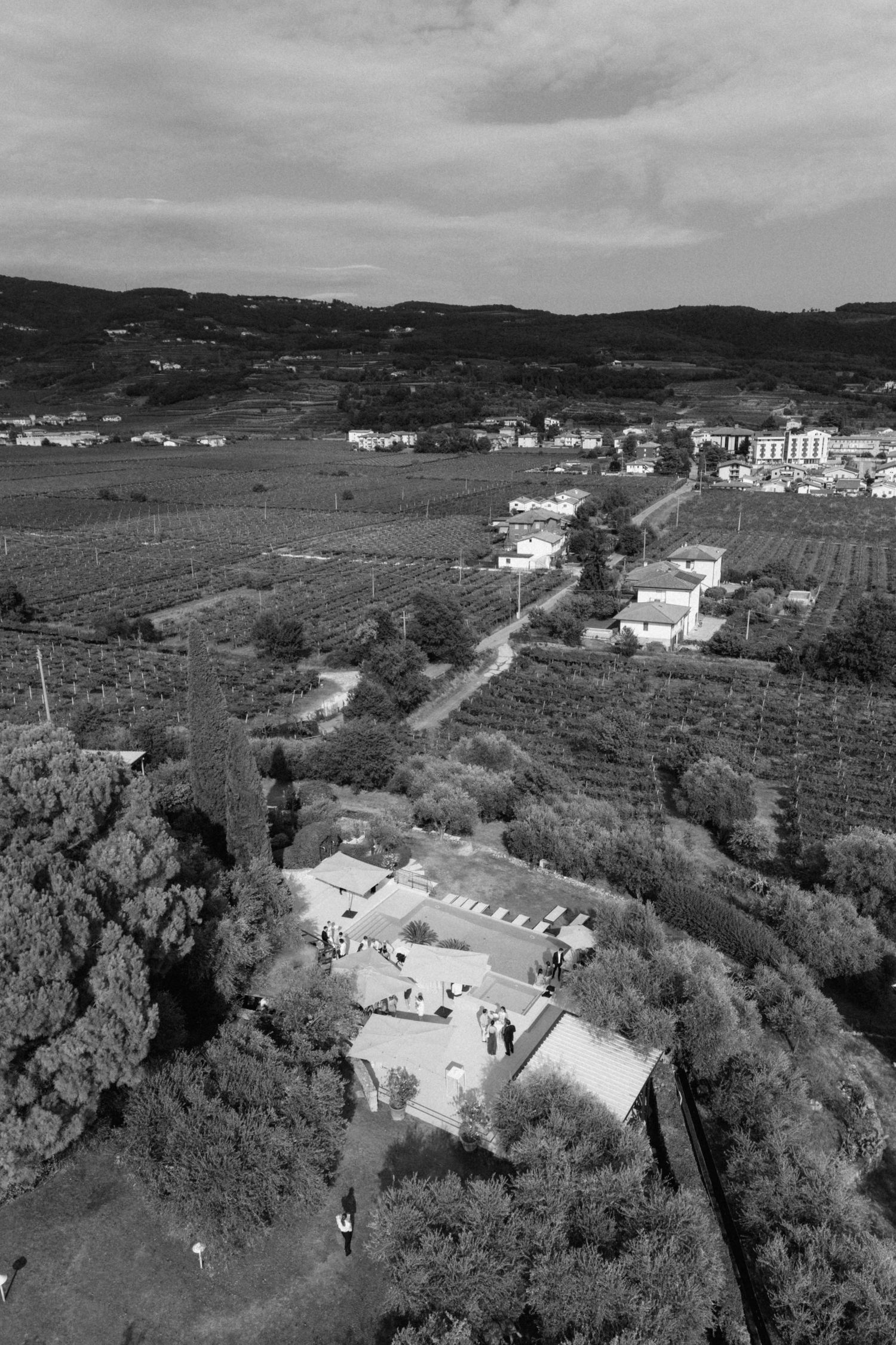 Aerial black and white view of a rural countryside estate surrounded by fields.