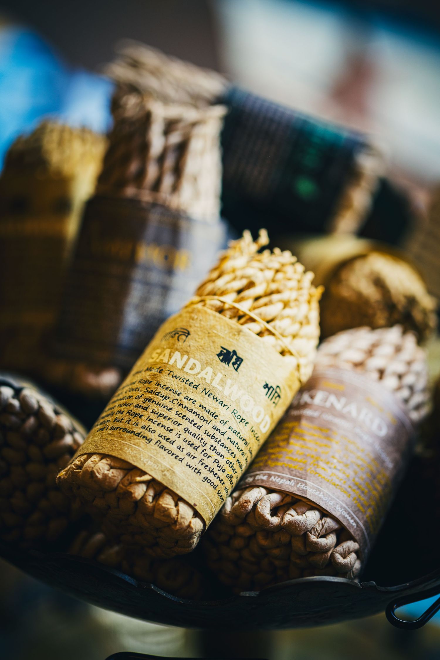 Handcrafted woven baskets filled with aromatic sandalwood incense sticks with vintage paper labels.