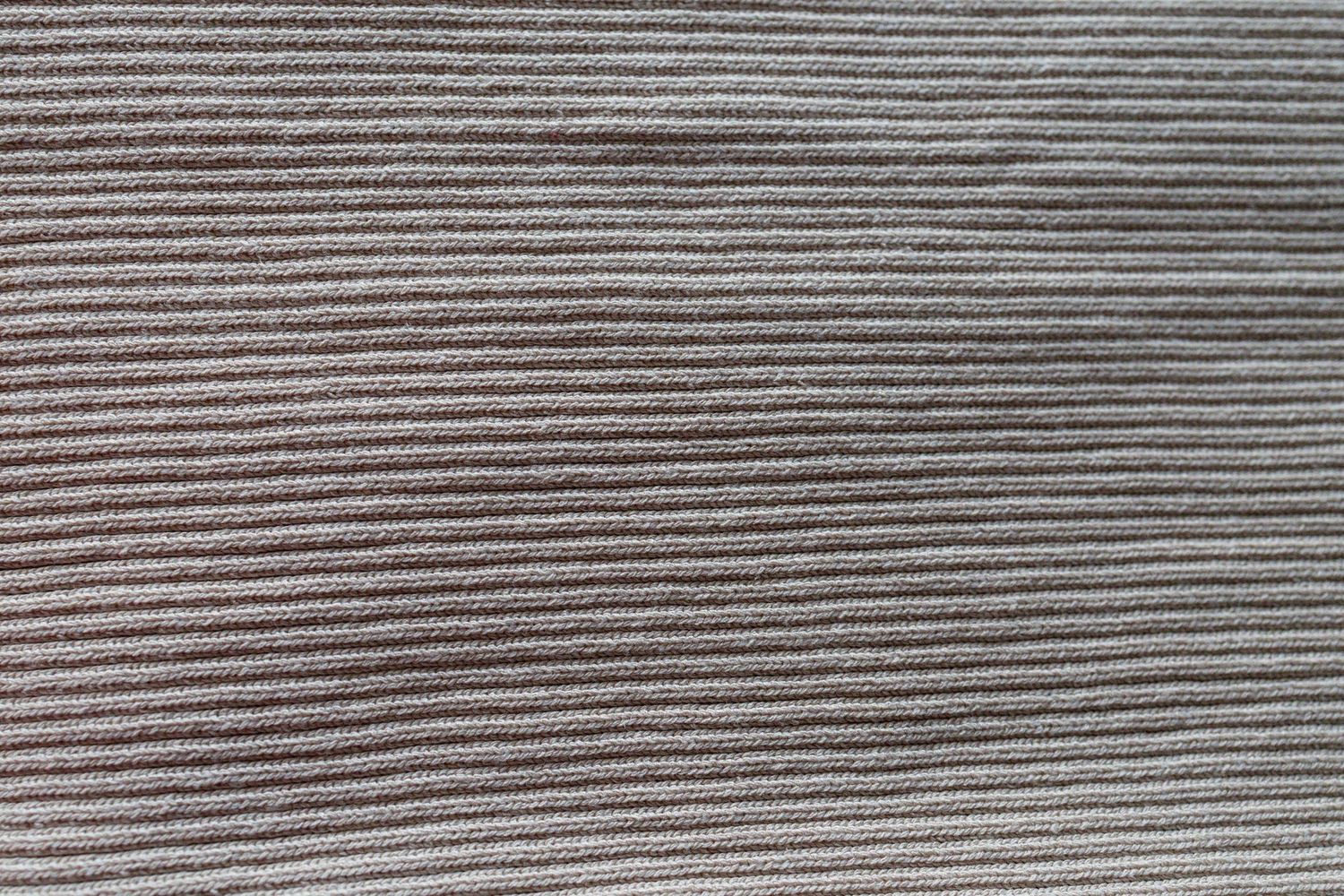 Close-up texture of gray ribbed corduroy fabric with parallel horizontal lines creating a classic striped pattern.