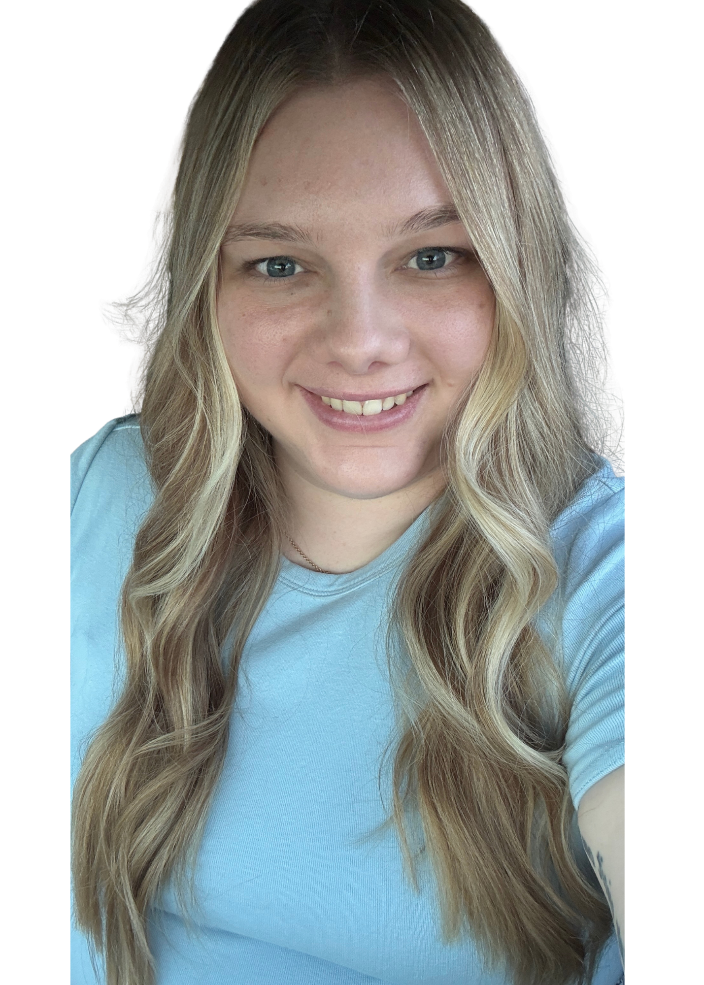 Smiling young girl with long blonde wavy hair in a light blue t-shirt.