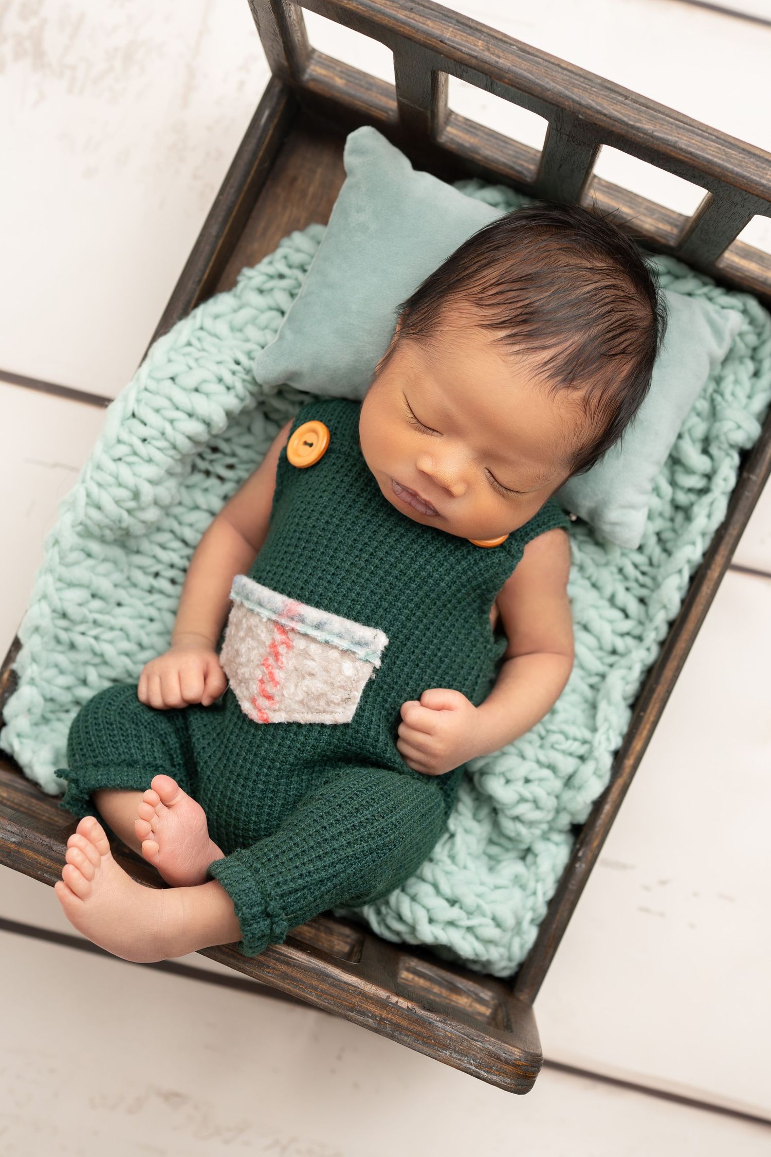 Sleeping newborn in bed. Captured by a sought-after professional newborn photographer in Woodland Hills, Los Angeles.