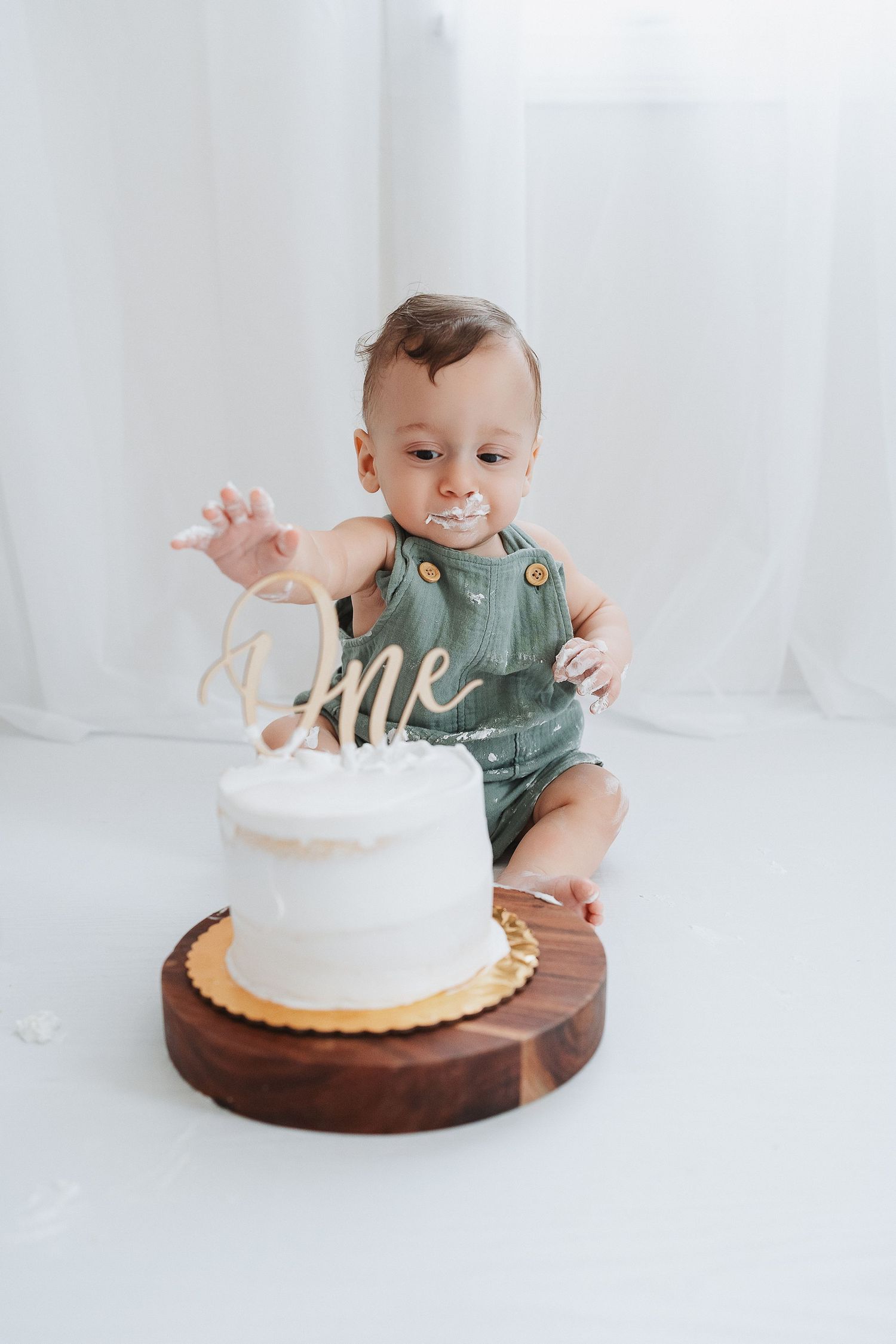 baby reaching for cake in our Woodland Hills studio. Amazing milestone photography in Los Angeles & the SF Valley.