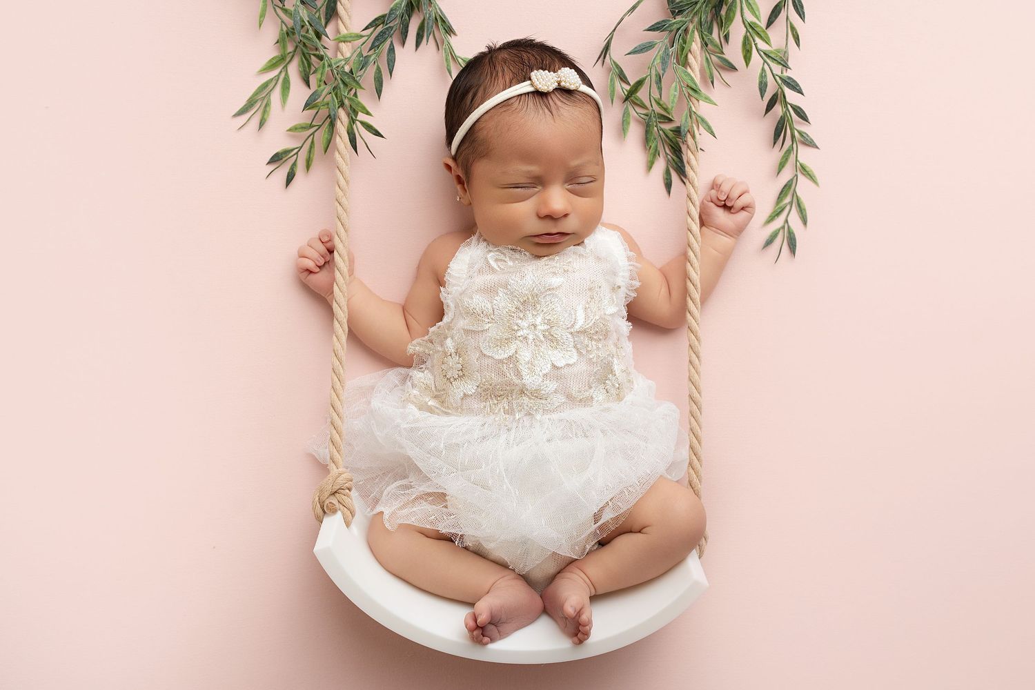 Sleeping newborn in swing. Captured by a sought-after professional newborn photographer in Woodland Hills, Los Angeles.