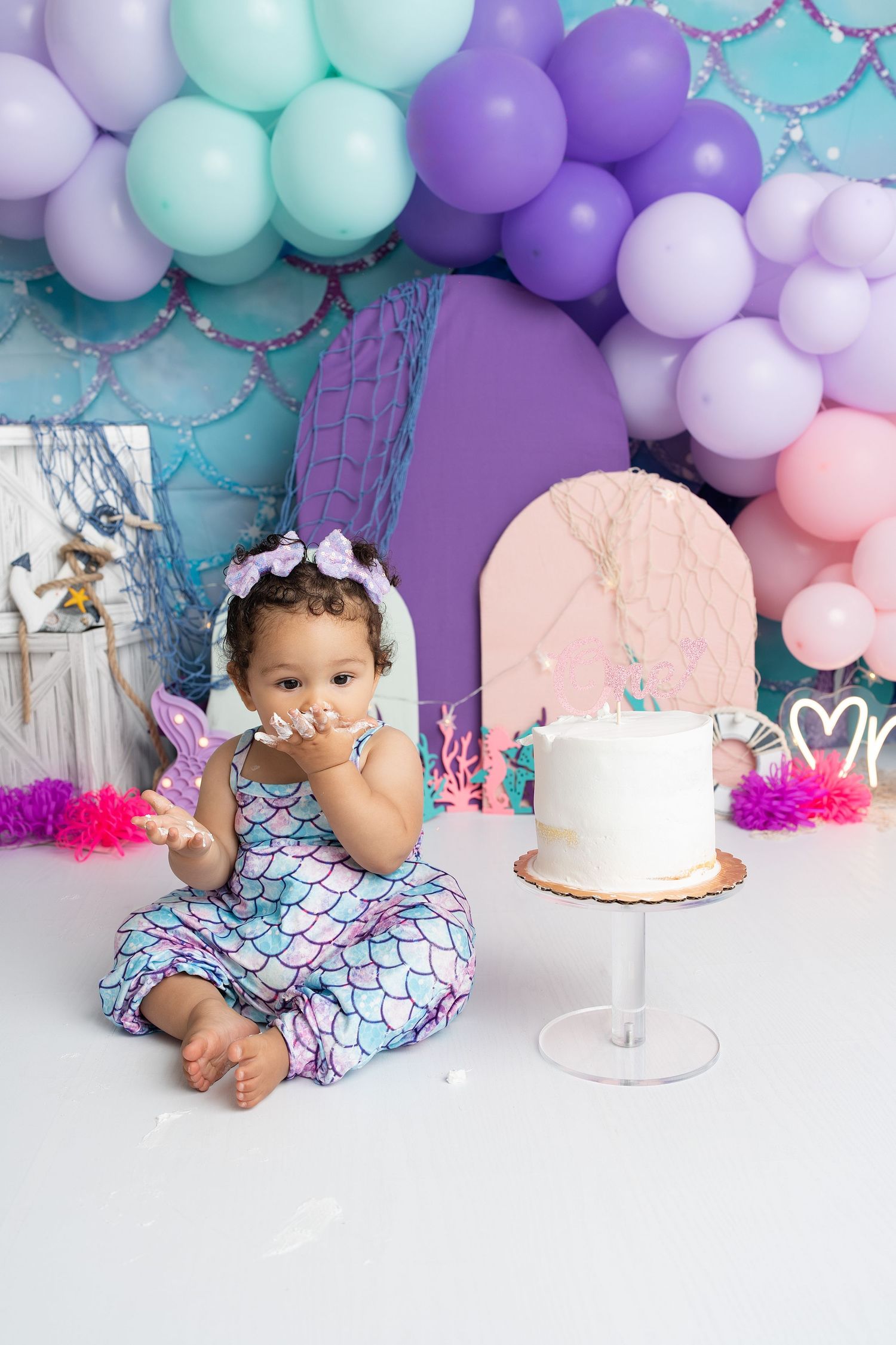 smiling baby eating cake in our Woodland Hills studio. Amazing milestone photography in Los Angeles & the SF Valley.