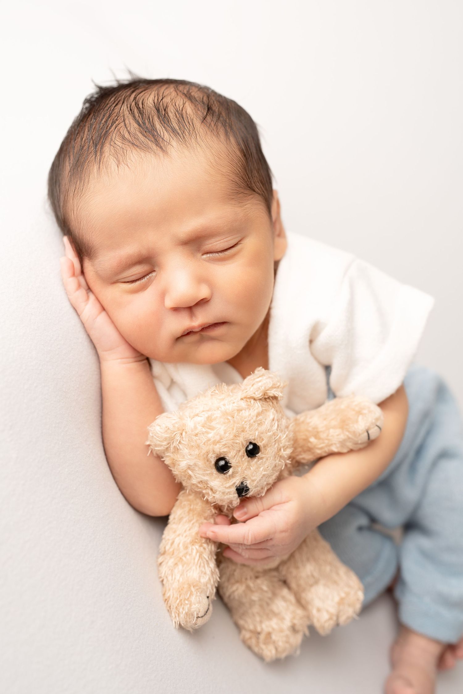 newborn holding bear prop. Captured by a sought-after professional newborn photographer in Woodland Hills, Los Angeles.