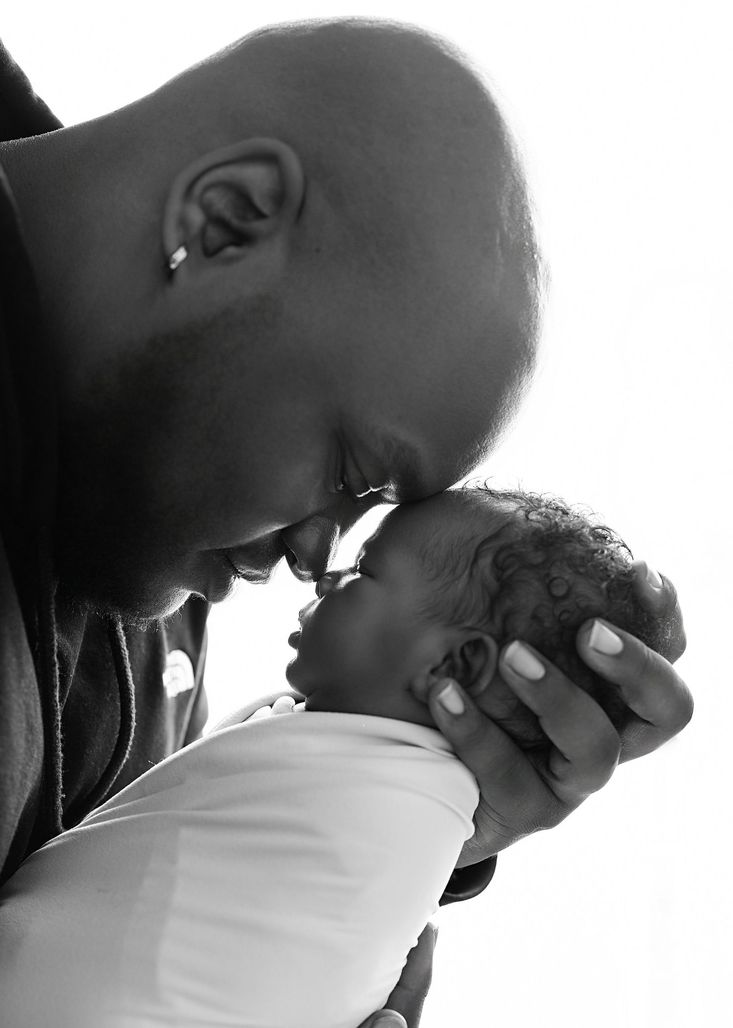 father with Sleeping newborn in hands. Captured by a sought-after professional newborn photographer in Woodland Hills, Los Angeles.