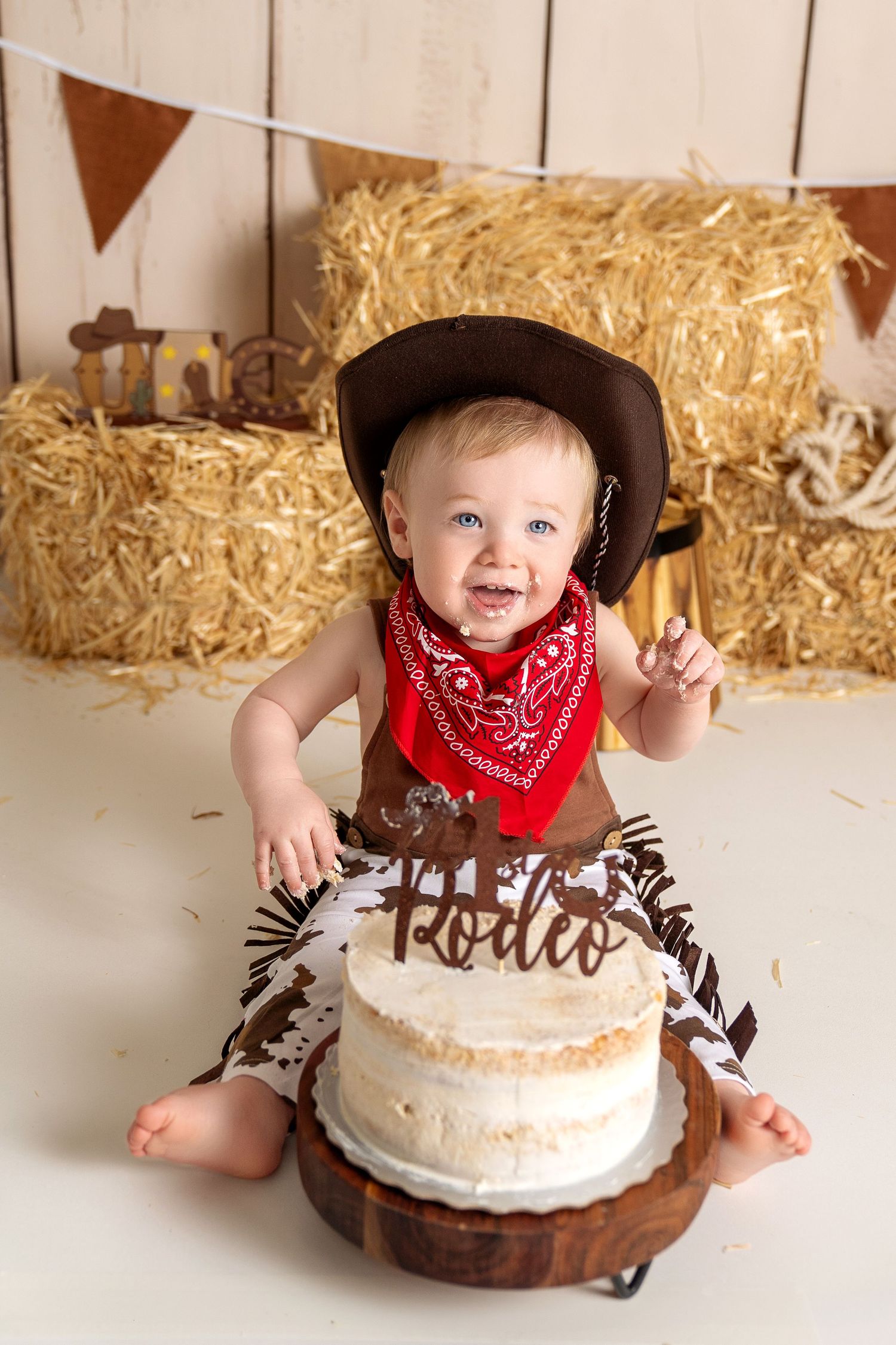 Smiling baby eating cake in our Woodland Hills studio. Amazing milestone photography in Los Angeles & the SF Valley.