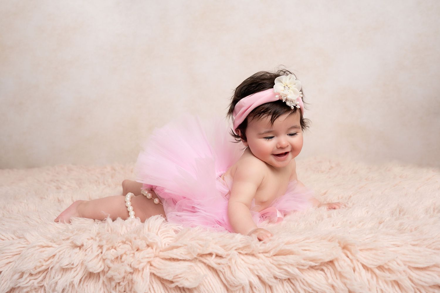 Smiling baby in a tutu in our Woodland Hills studio. Amazing milestone photography in Los Angeles & the SF Valley.