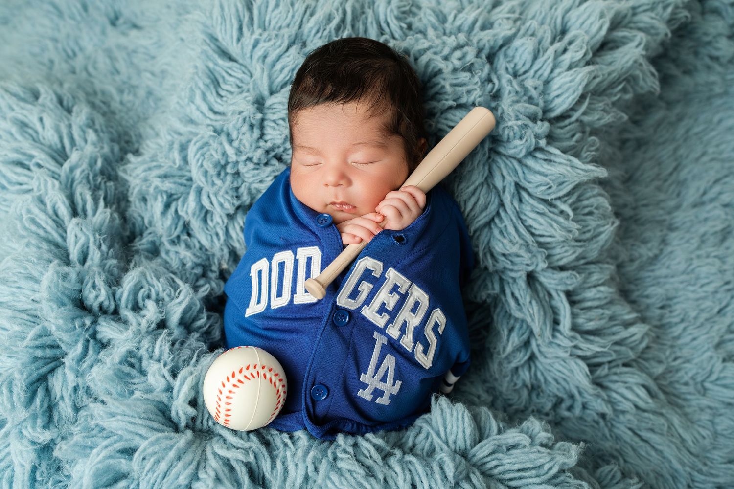 newborn in dodgers jersey. Captured by a sought-after professional newborn photographer in Woodland Hills, Los Angeles.
