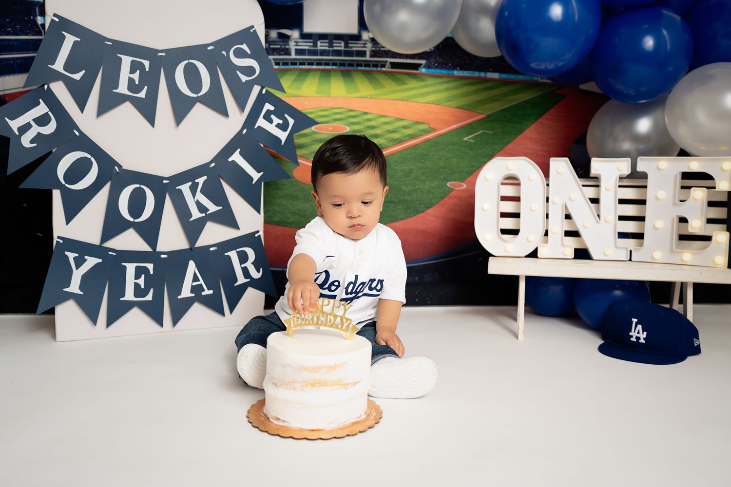 Smiling baby eating cake in our Woodland Hills studio. Amazing milestone photography in Los Angeles & the SF Valley.