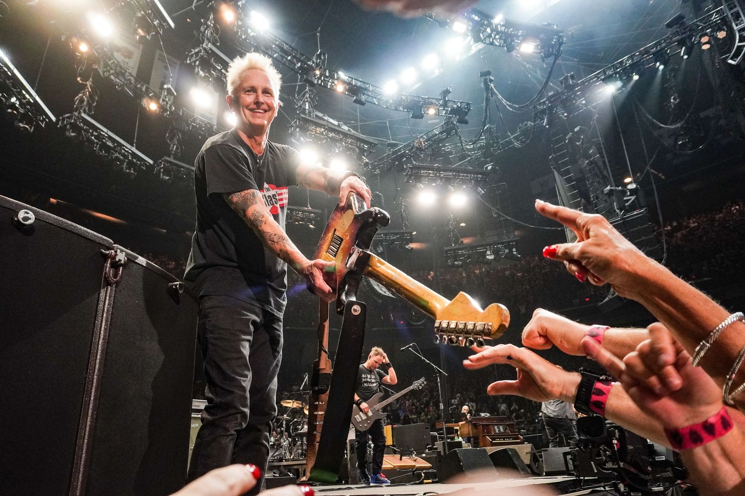 Mike McCready holding his guitar out to fans during Pearl Jam’s Hamilton show, photographed by Canadian concert photographer Lisa Mark.