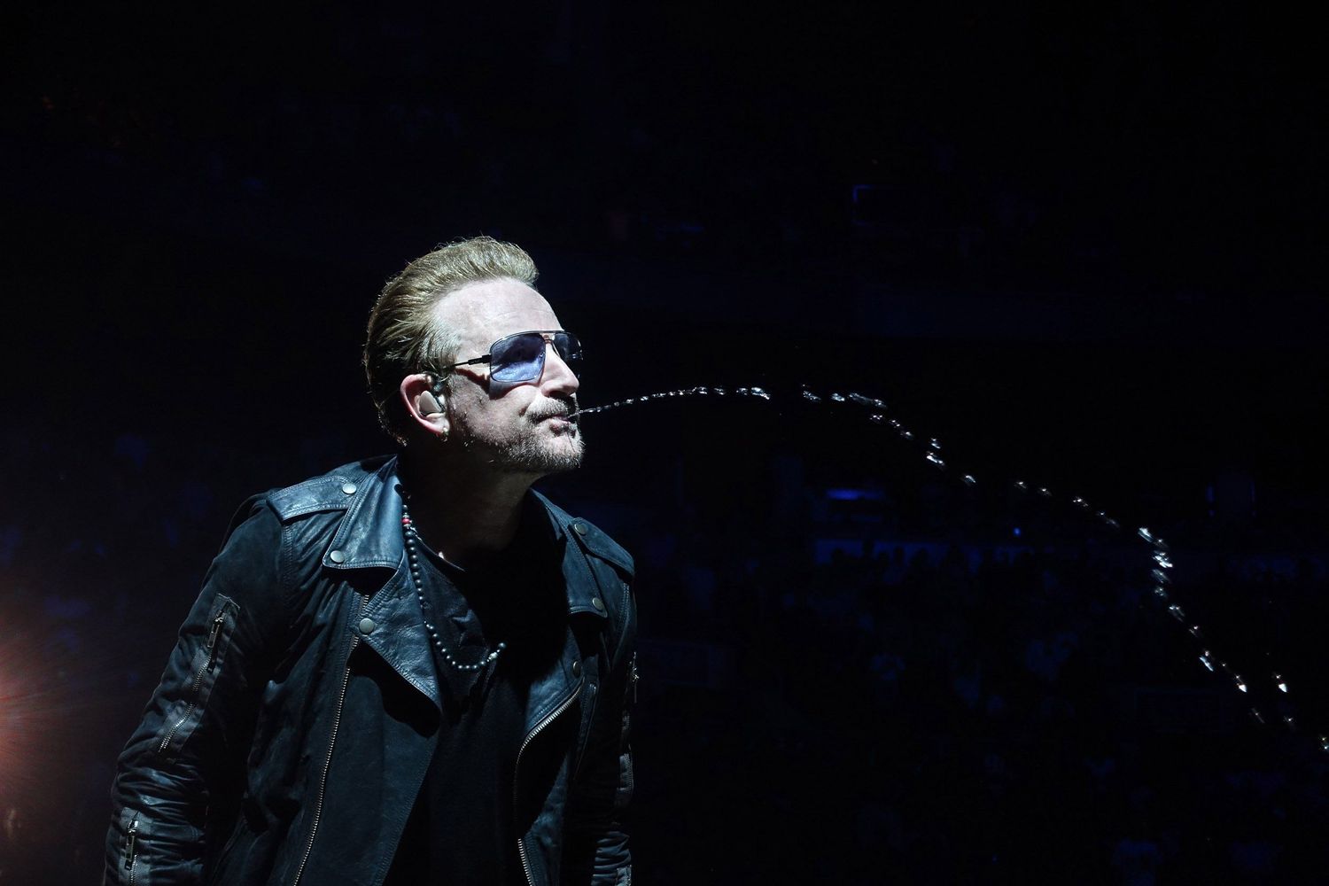 Bono playfully spitting water while performing live with U2 at Air Canada Centre in Toronto in July 2015, photographed by Lisa Mark.