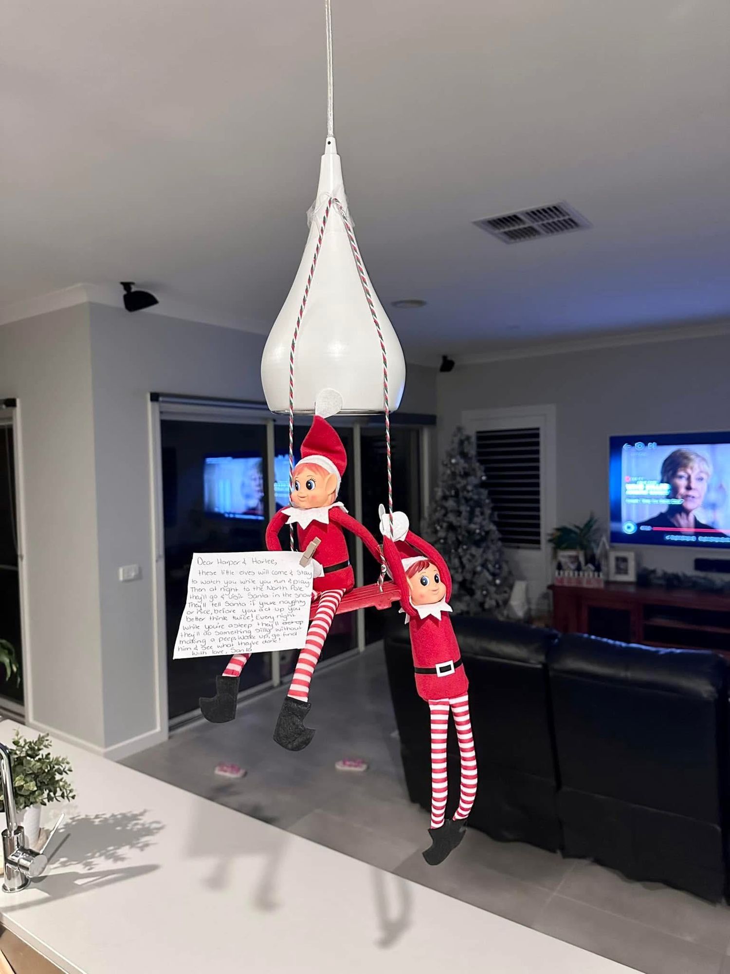 A sequence of photos showing an Elf on the Shelf decoration hanging from the ceiling in different positions in a living room.