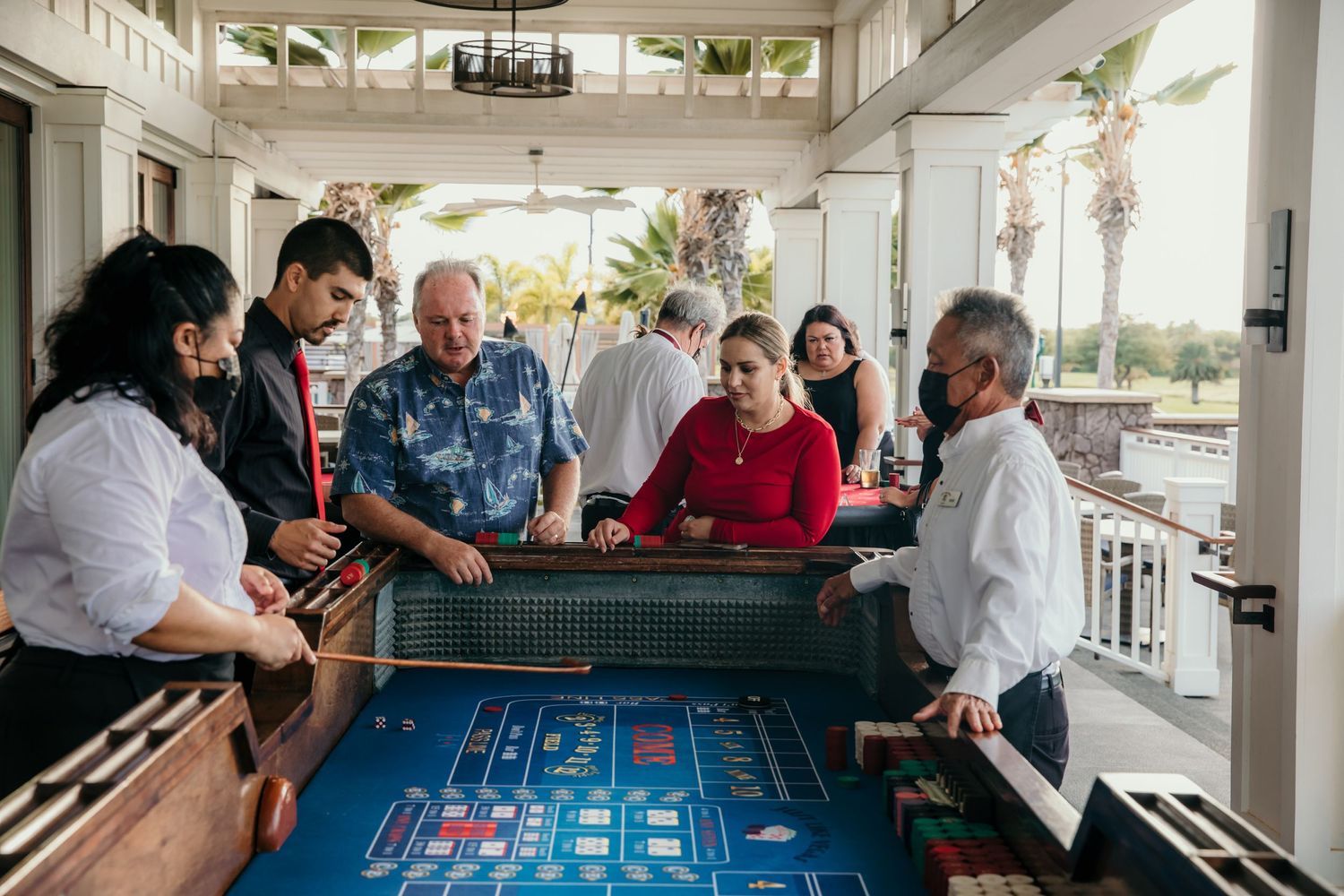 People gathered around a craps table enjoying a casino-style game at an outdoor venue.