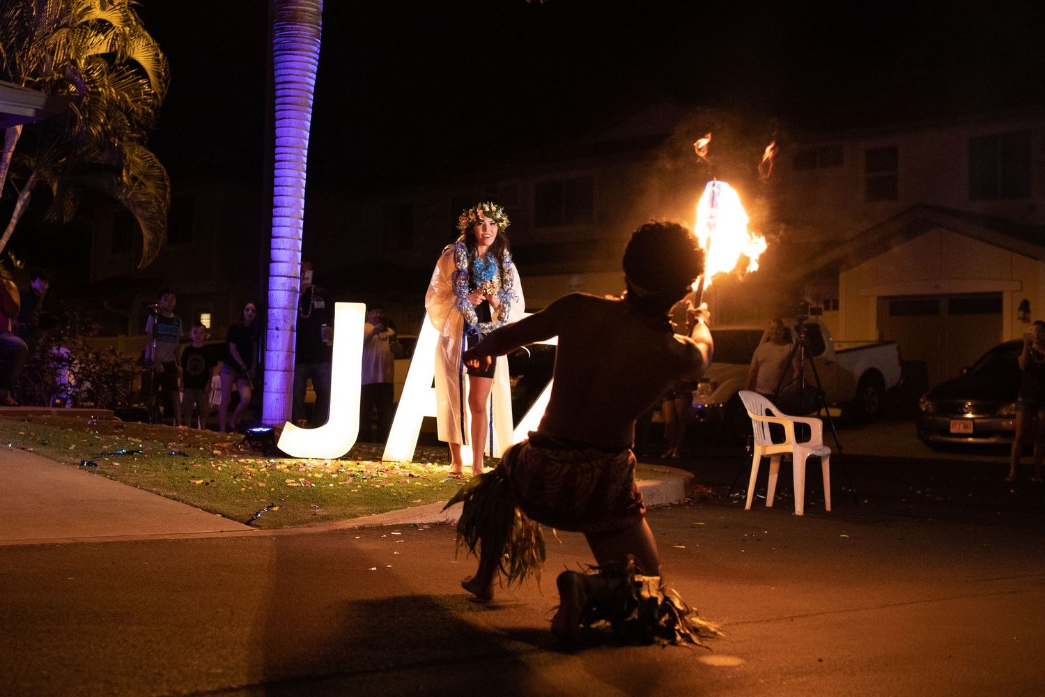 A fire performer creates an impressive flame display during a nighttime outdoor event.