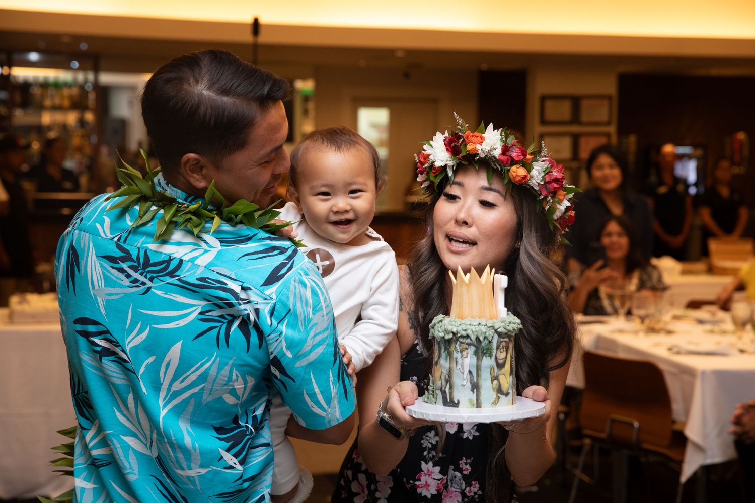 Family celebration moment at restaurant with cake and festive decorations.