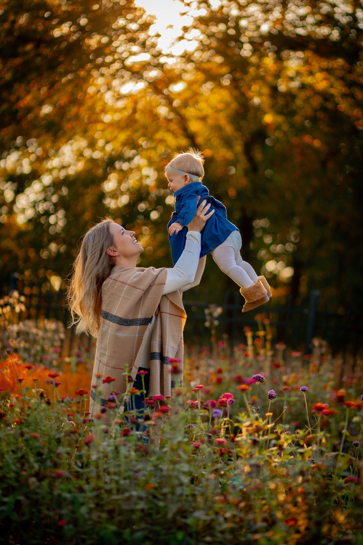 A baby and mother engage in play while the setting sun creates a beautiful glow