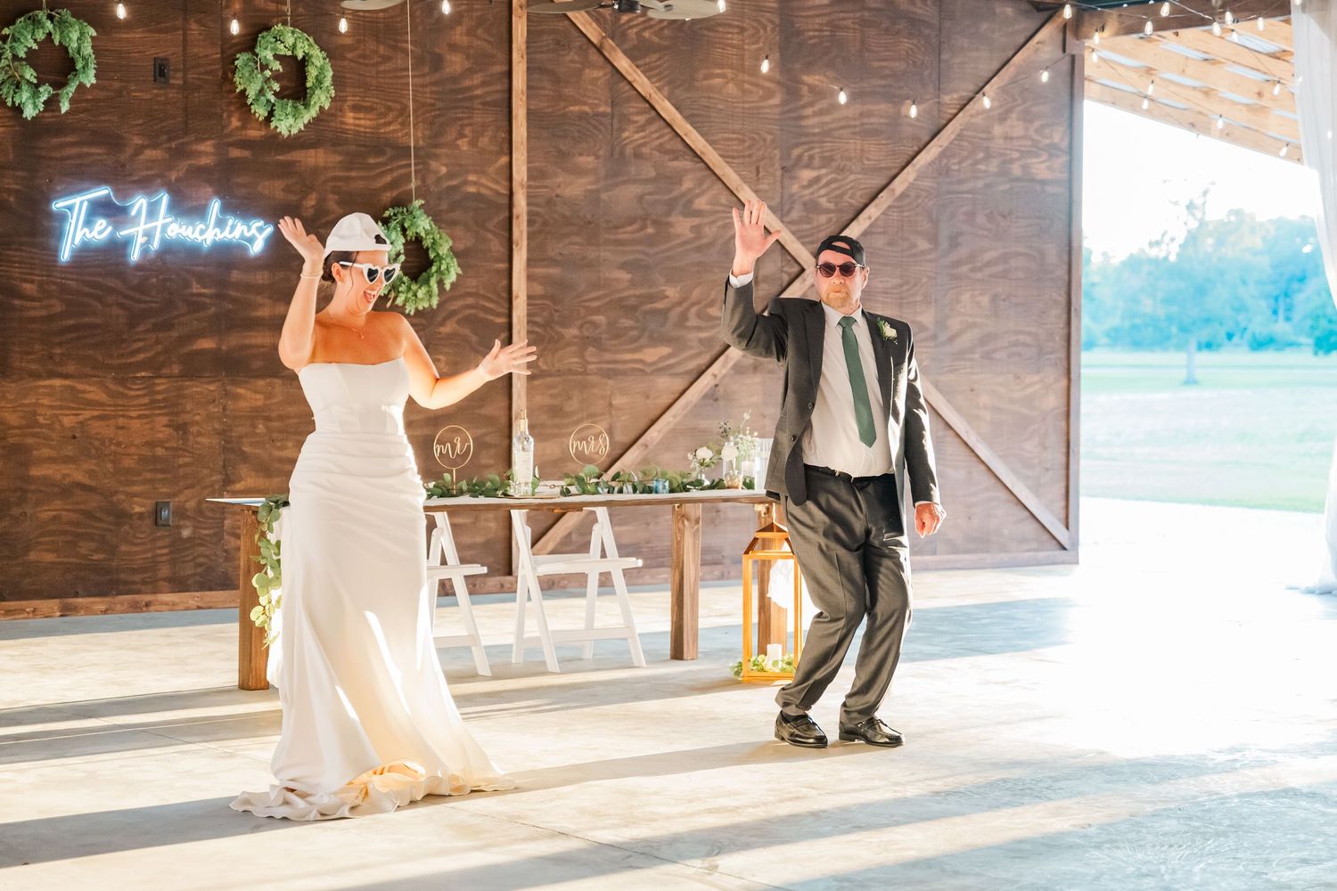 Bride and groom make a fun entrance into their rustic barn wedding reception with sunglasses.