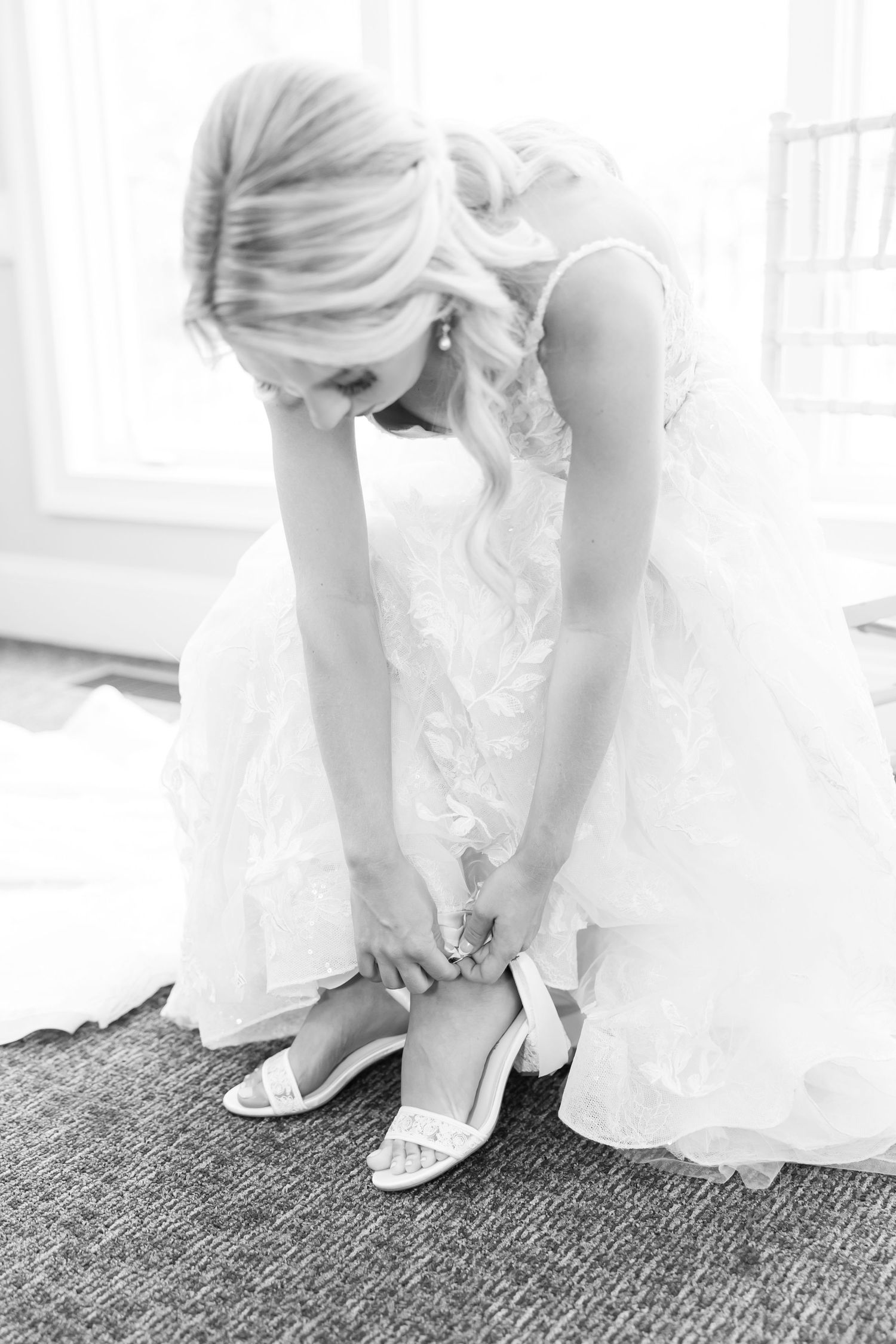 Close-up shots of a bride putting on white wedding shoes against a carpeted floor.